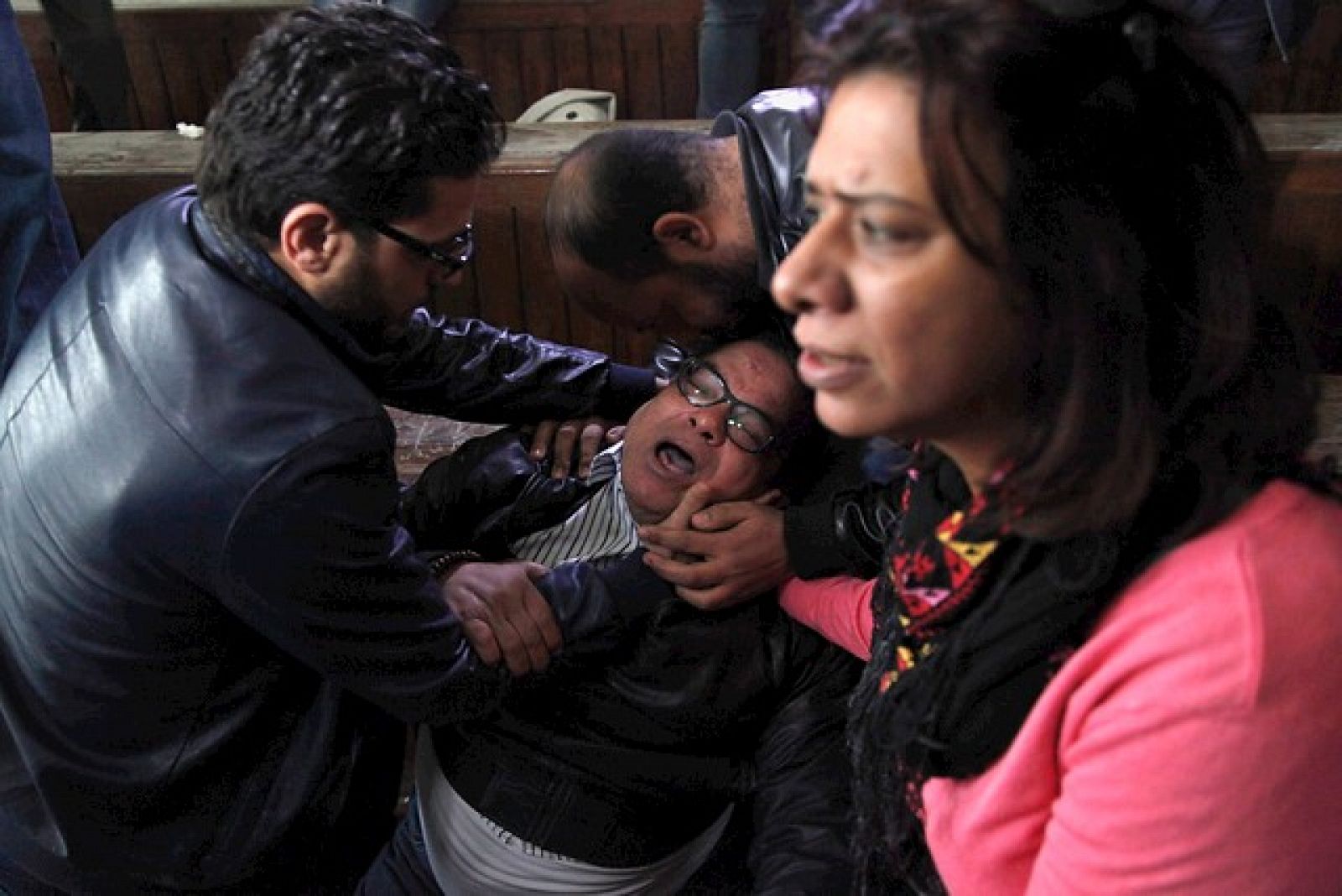 El padre de uno de los condenados llora al oir el veredicto de su hijo en un tribunal de El Cairo.