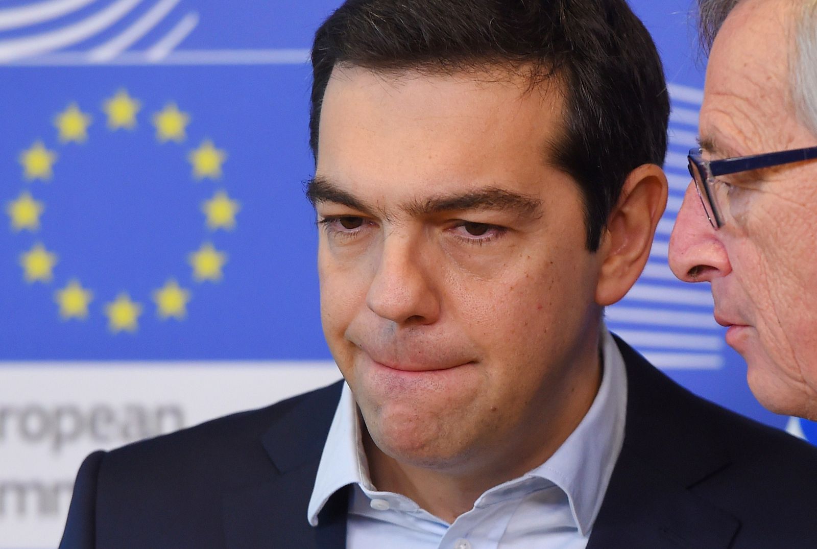El primer ministro griego, Alexis Tsipras, escuchando al presidente de la Comisión Europea