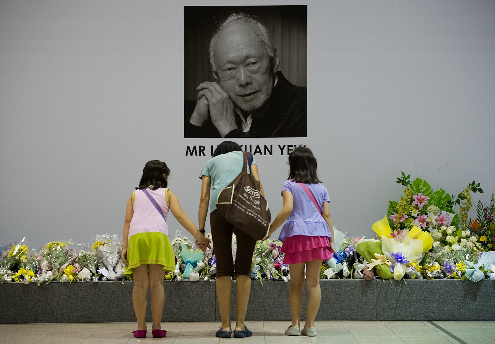 Singapurenses muestran su respeto ante una fotografía de Lee Kuan Yew, exprimer ministro del país, fallecido a los 91 años