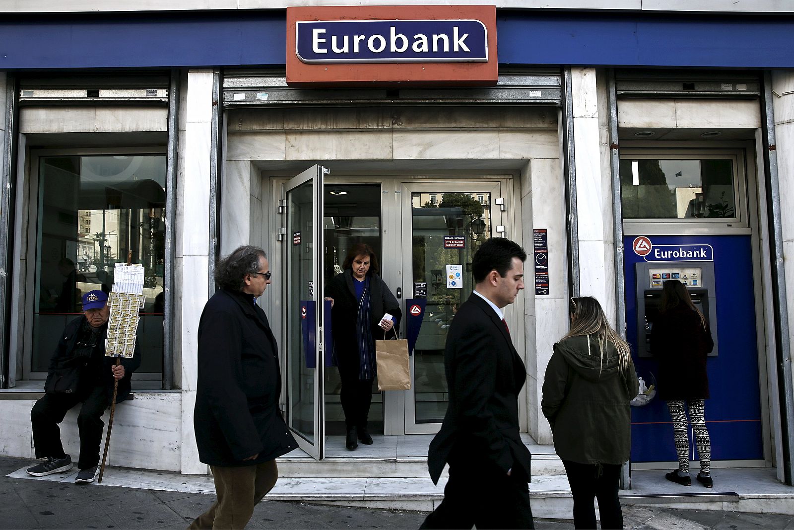 Una persona retira dinero de un cajero de una sucursal de Eurobank en Atenas