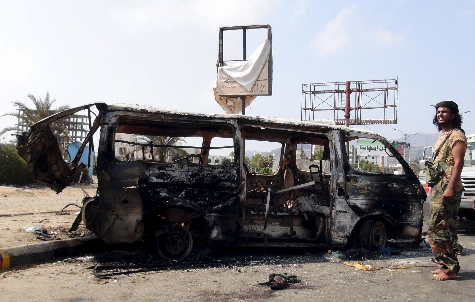 Un hombre permanece junto a una furgoneta destrozada en un bombardeo en la ciudad yemení de Adén.