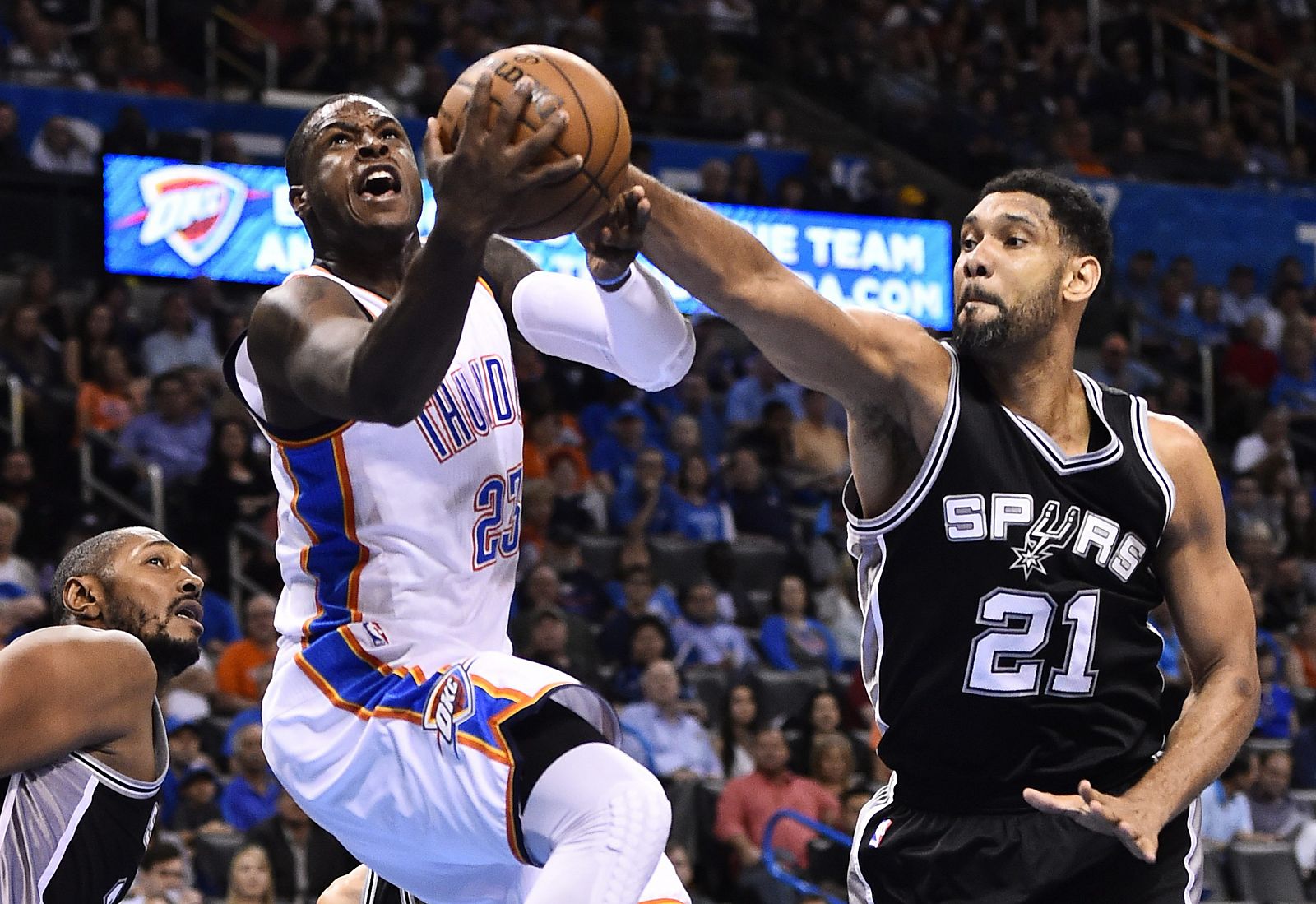 El jugador de los Spurs Tim Duncan disputa el balón con Dion Waiters de los Thunder.