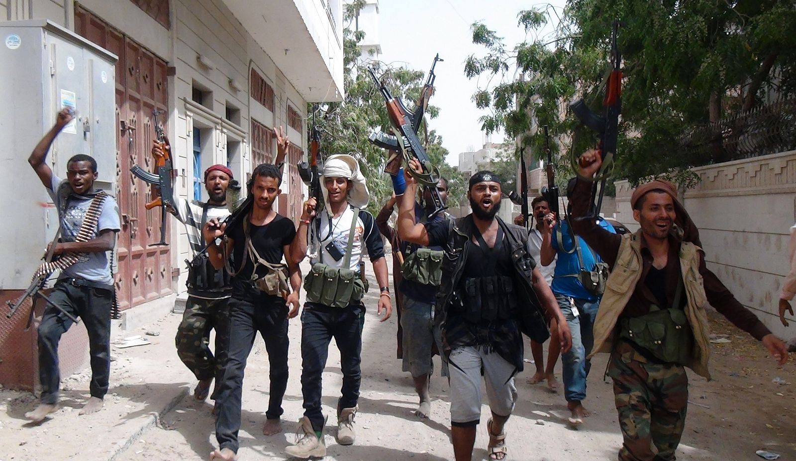 Combatientes leales al presidente Hadi pasean este miércoles con las armas en alto en la ciudad de Adén.