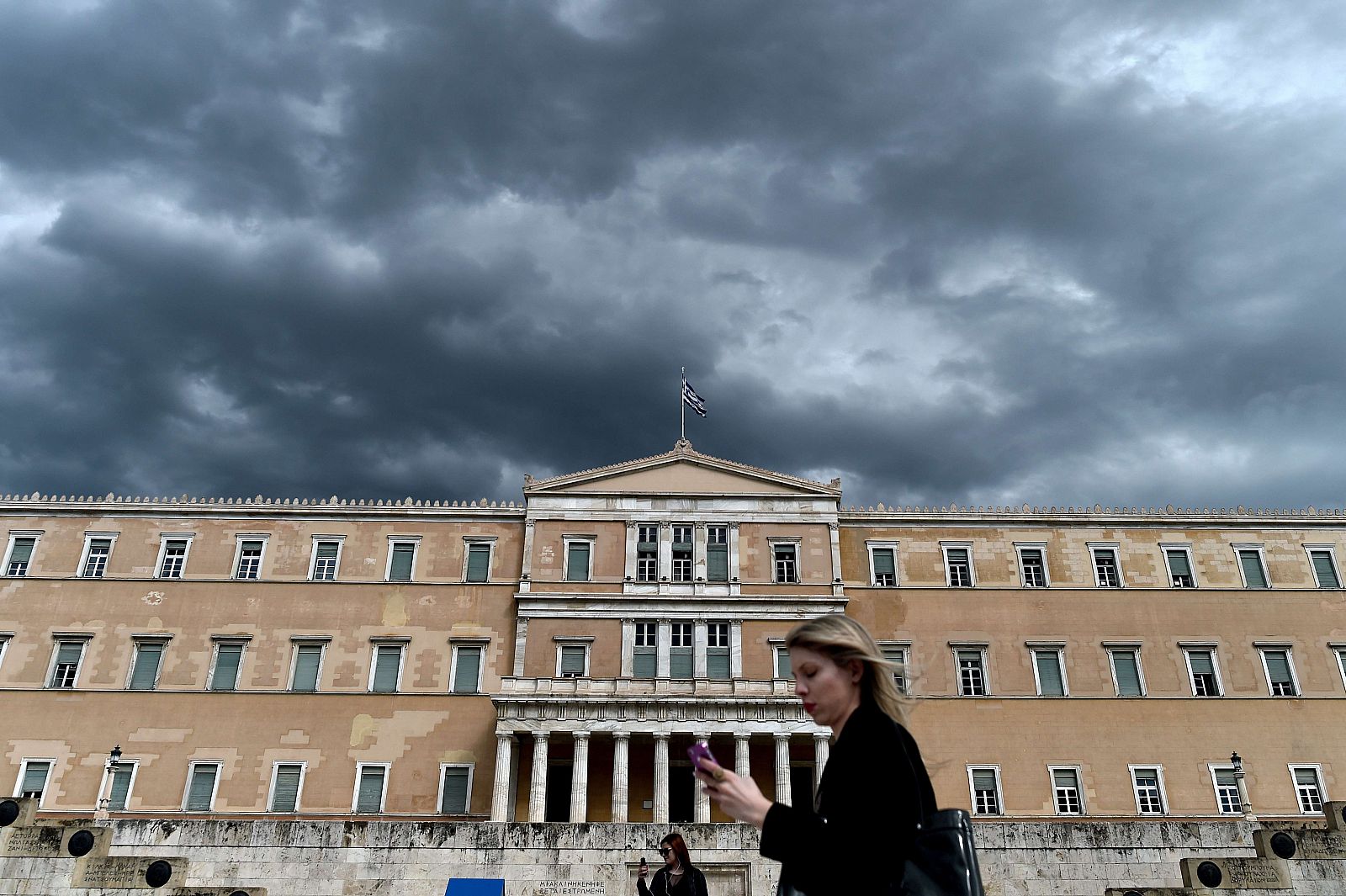 Una transeúnte pasa delante del Parlamento griego en Atenas