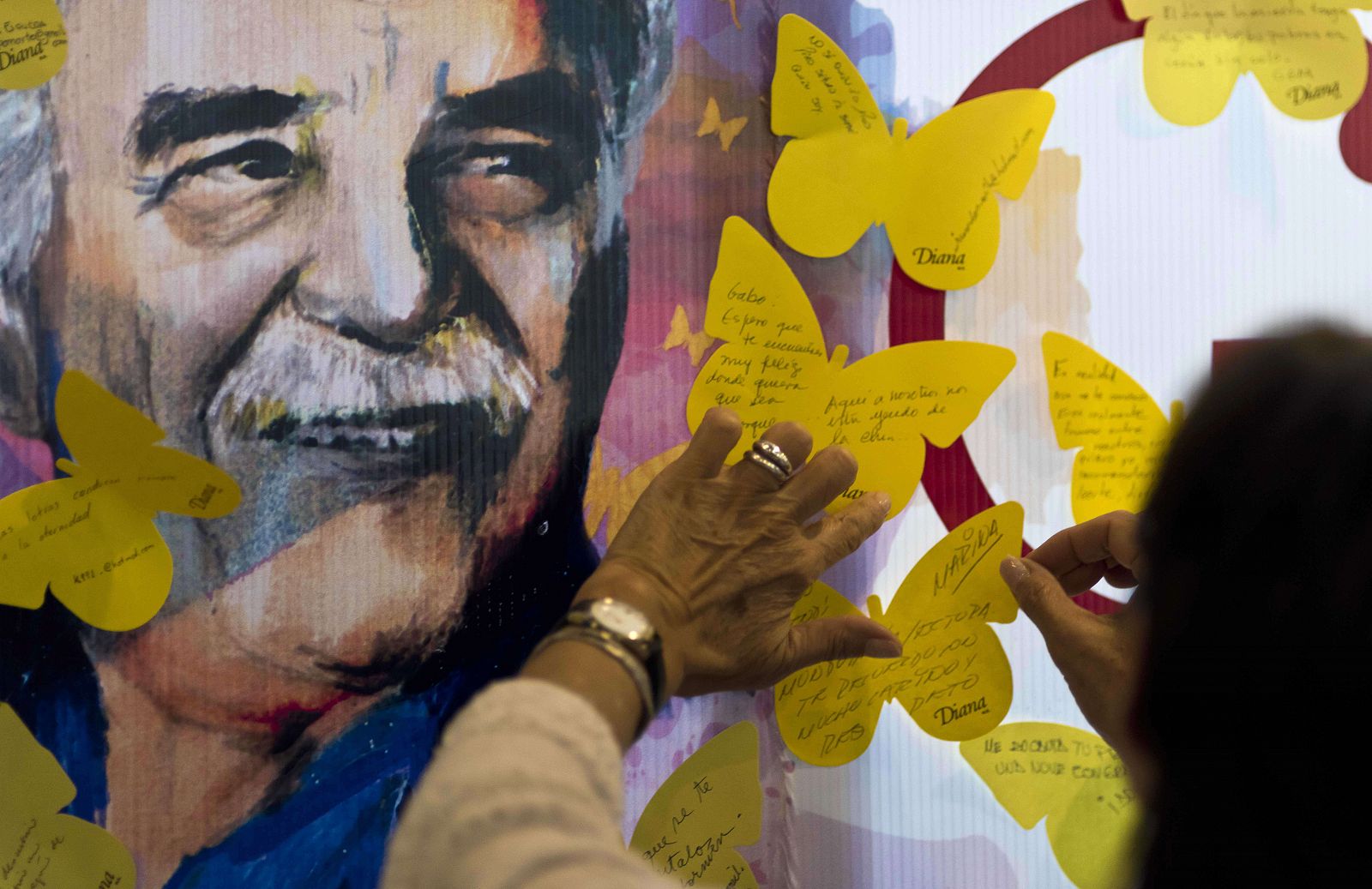 Una mujer pega una mariposa de papel amarillo con sus recuerdos sobre Gabriel García Márquez en una librería de Ciudad de México.