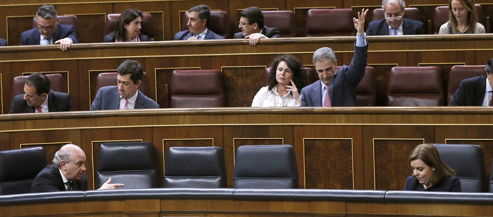 La vicepresidenta del Gobierno, Soraya Sáenz de Santamaría, conversa con el ministro del Interior, Jorge Fernández Díaz, durante el pleno del Congreso