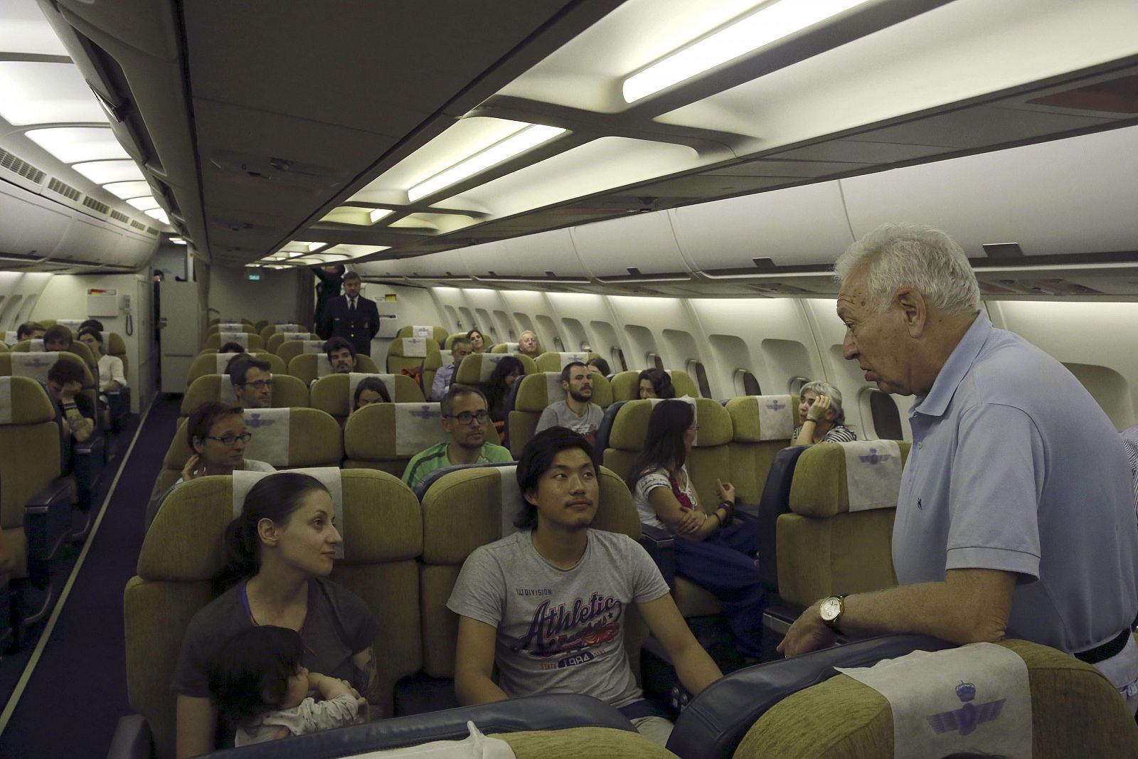 El ministro de Asuntos Exteriores, José Manuel García-Margallo, conversa con varios de los españoles rescatados tras el terremoto de Nepal en el avión que les trae a España desde Nueva Delhi.