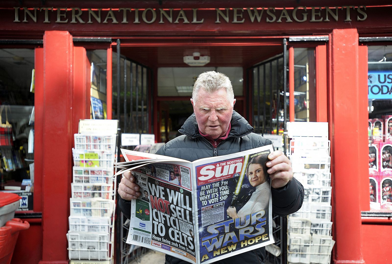 Un hombre posa para fotos mientras lee la edición escocesa del diario The Sun