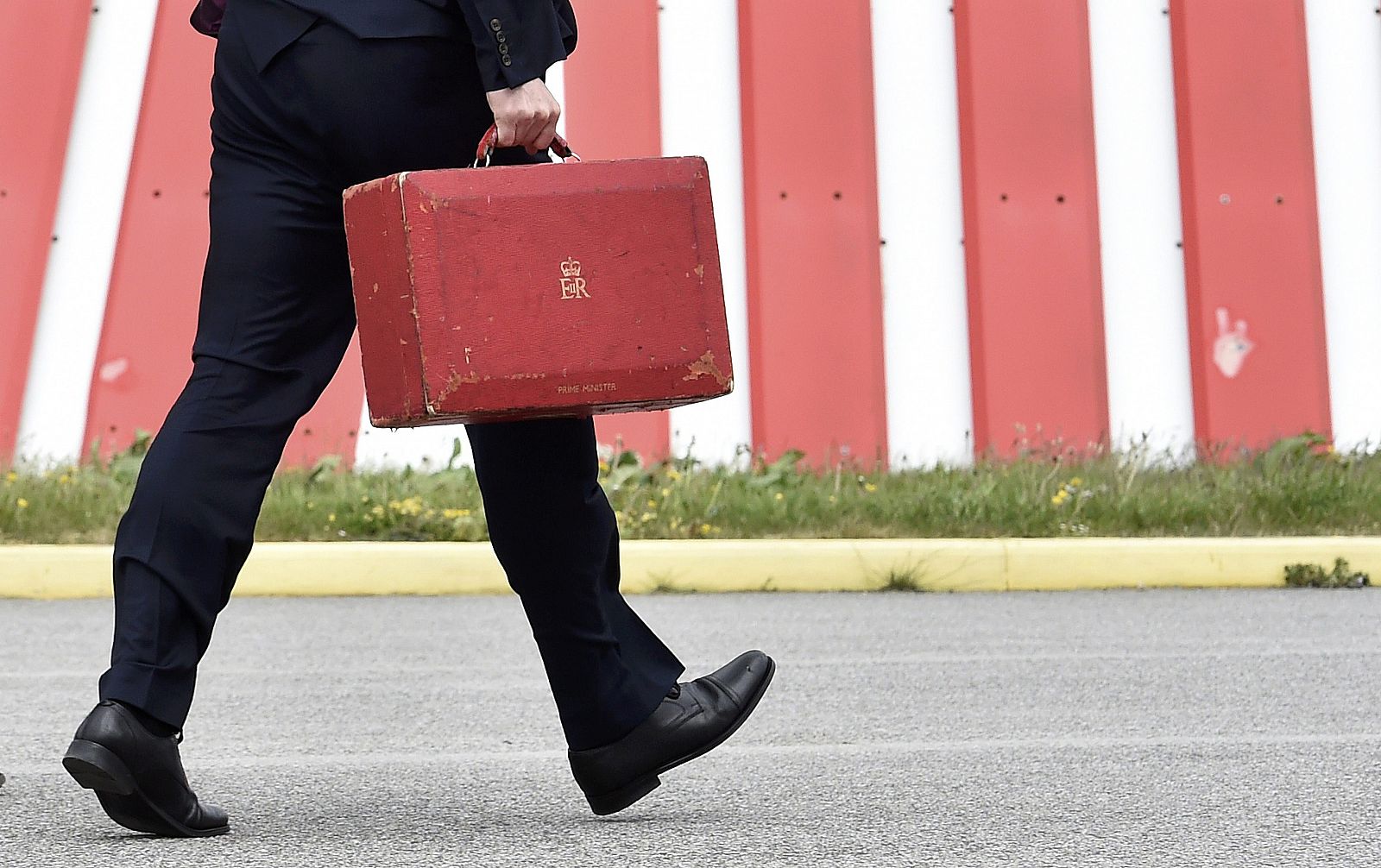 El primer ministro británico, David Cameron, camina con el maletín ministerial en el aeropuerto de Newquay, al suroeste de Inglaterra.