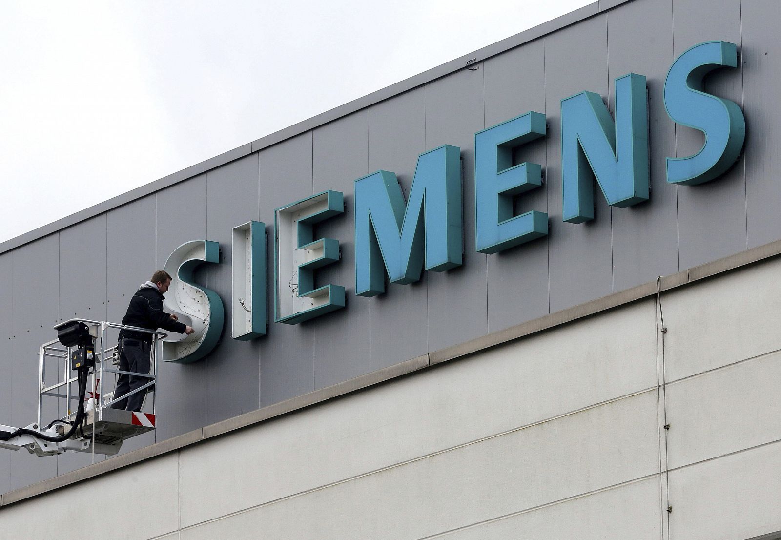 Un empleado repara el logotipo de Siemens en una de sus oficinas en Duisburgo