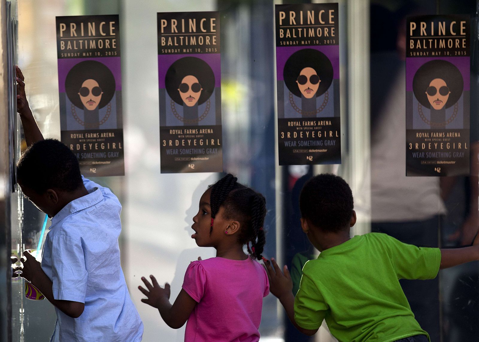 Unos niños miran a través del cristal la entrada de los fans al concierto benéfico celebrado por Prince en Baltimore.