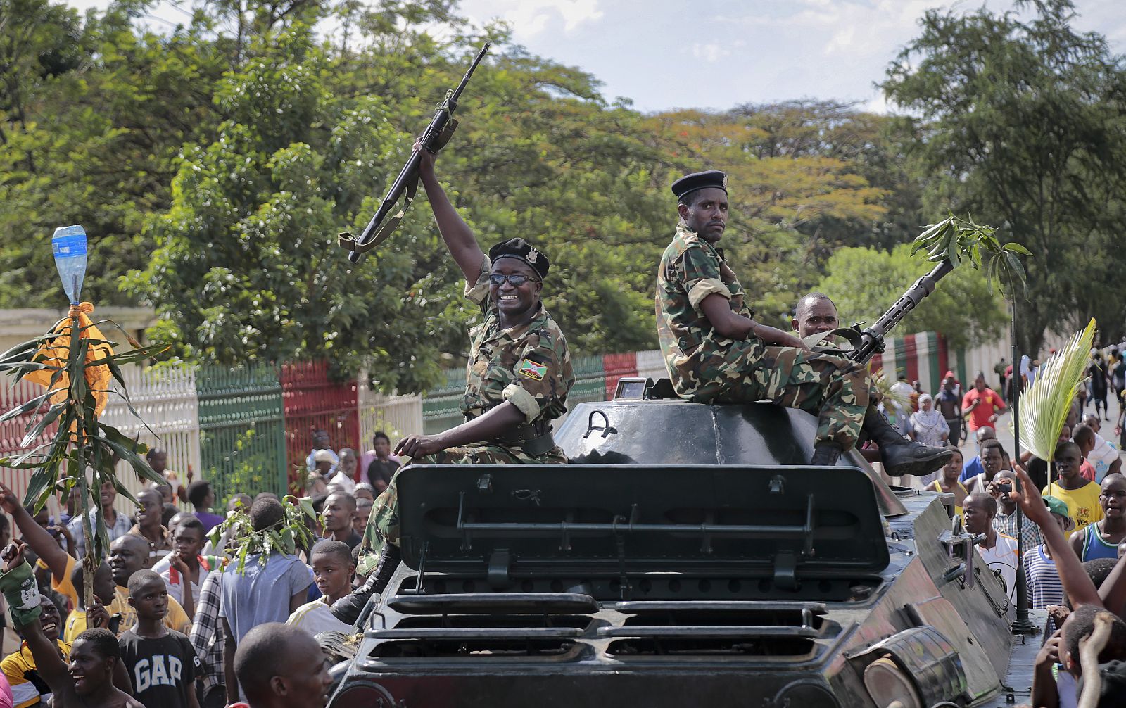Un soldado del ejército de Burundi levanta su fusil sobre un tanque caundo se unen a los manifestantes
