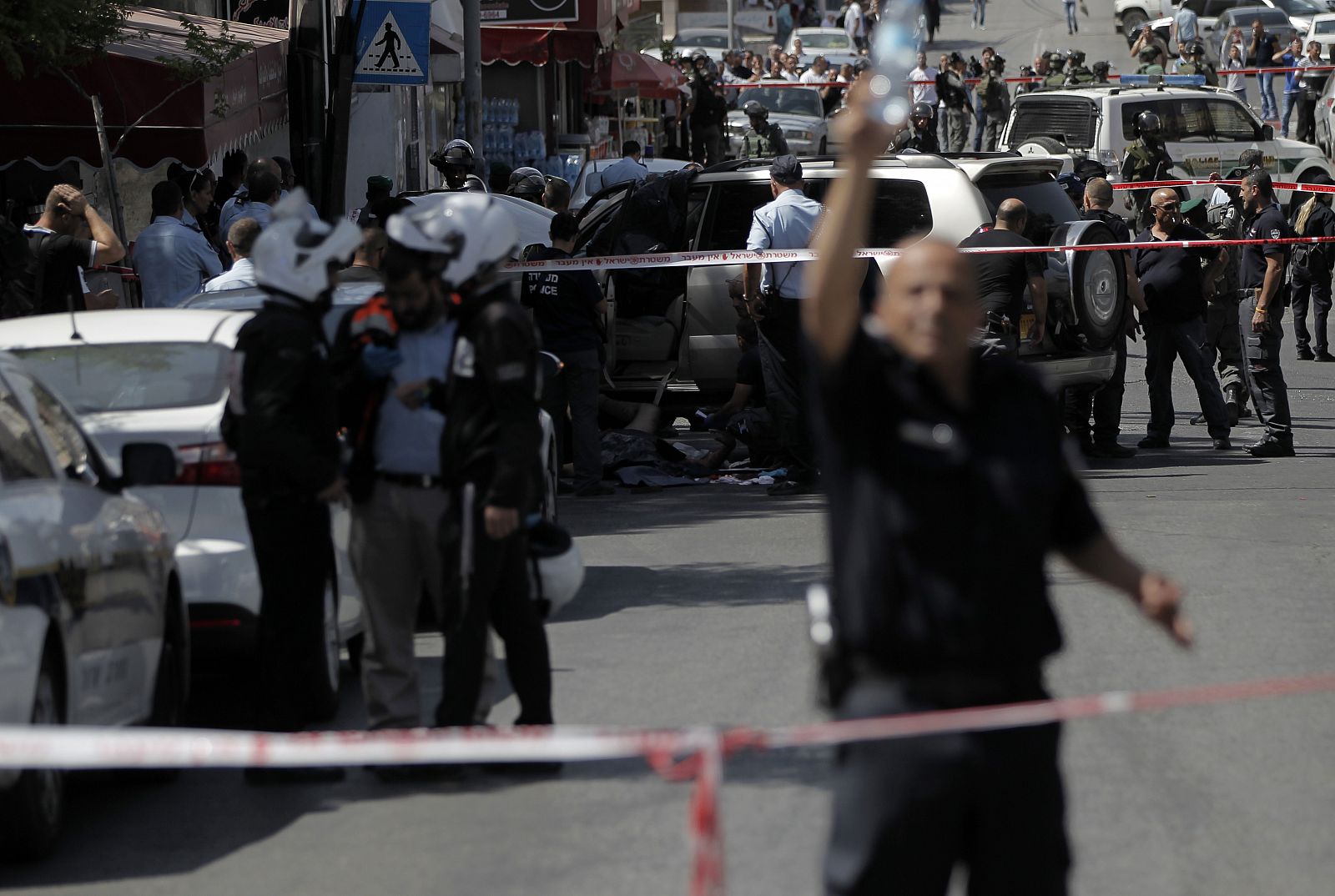 Policía israelí rodea el lugar del atropello en el que han resultado heridos dos agentes y un palestino ha sido abatido, en Jerusalén