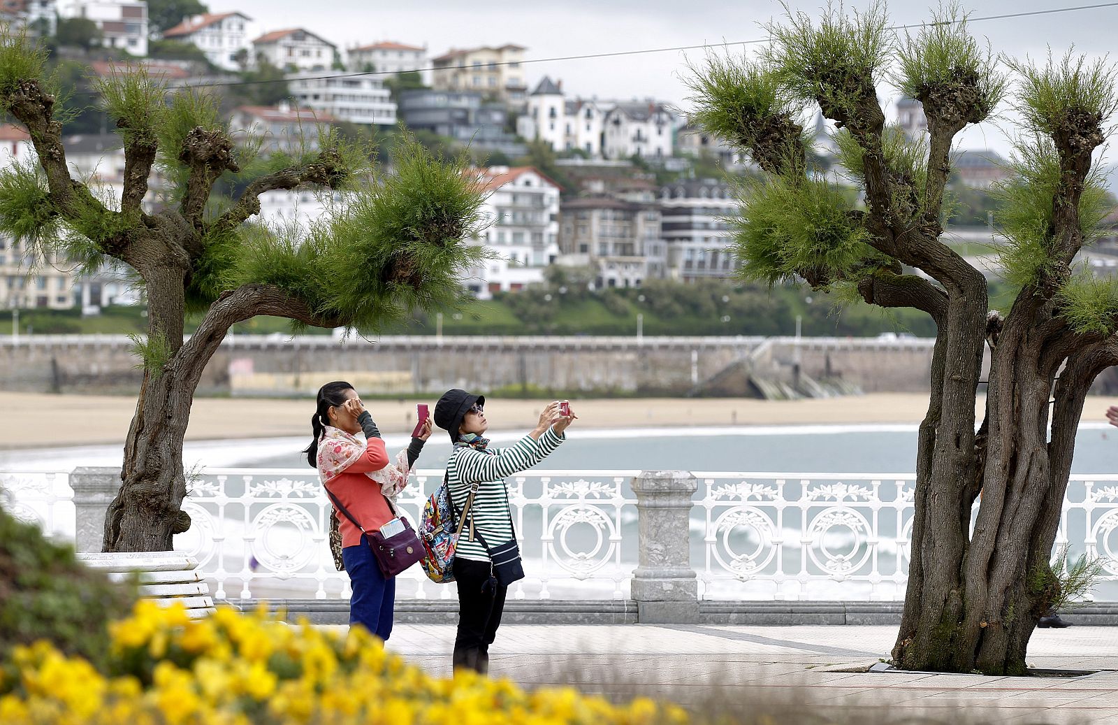 Dos turistas fotografían el parque Alderdi Eder de San Sebastián