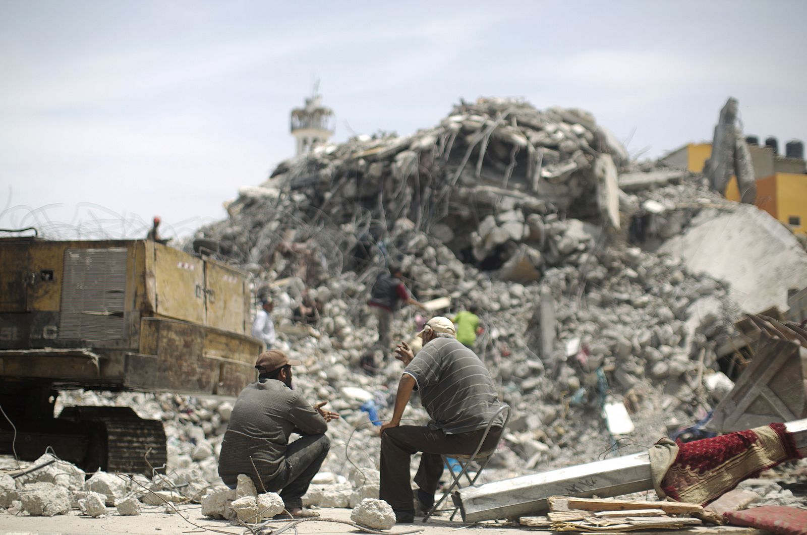 Palestinos de Gaza se sientan en medio de los escombros de las casas que fueron destruidas durante la guerra