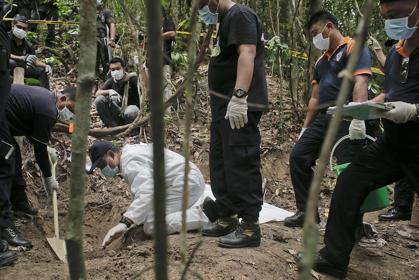Un equipo de la policía forense malasia excava una fosa descubierta en las colinas Wang Burma en Wang Kelian, Perlis (Malasia)