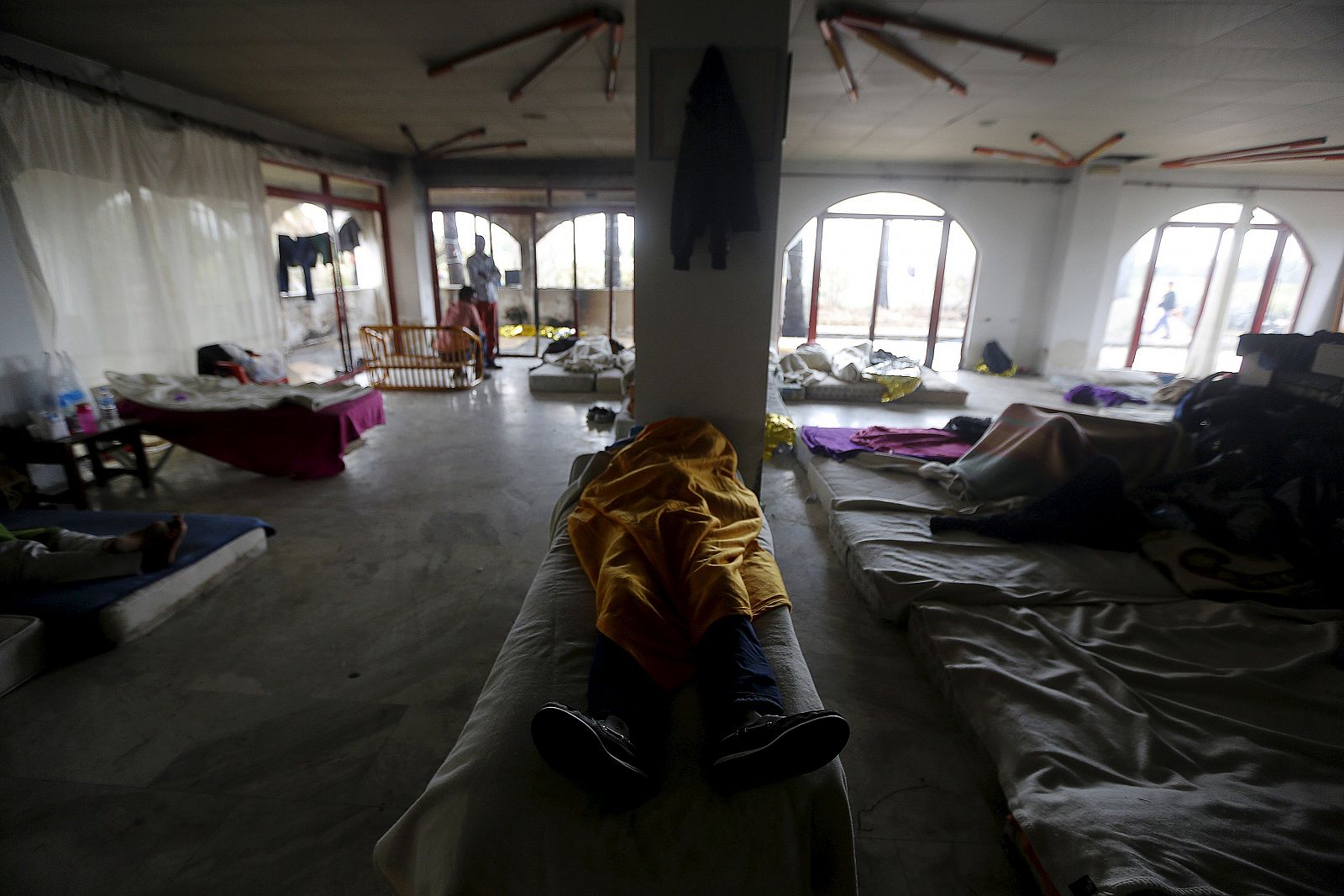 Inmigrantes y solicitantes de asilo descansan en un hotel abandonado en la isla griega de Cos este jueves.
