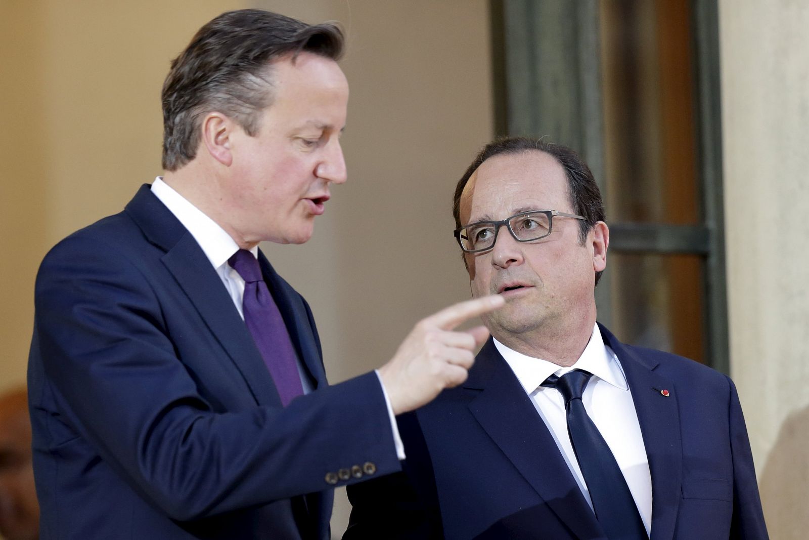 French President Hollande accompanies Britain's Prime Minister Cameron as he leaves the Elysee Palace after a meeting in Paris