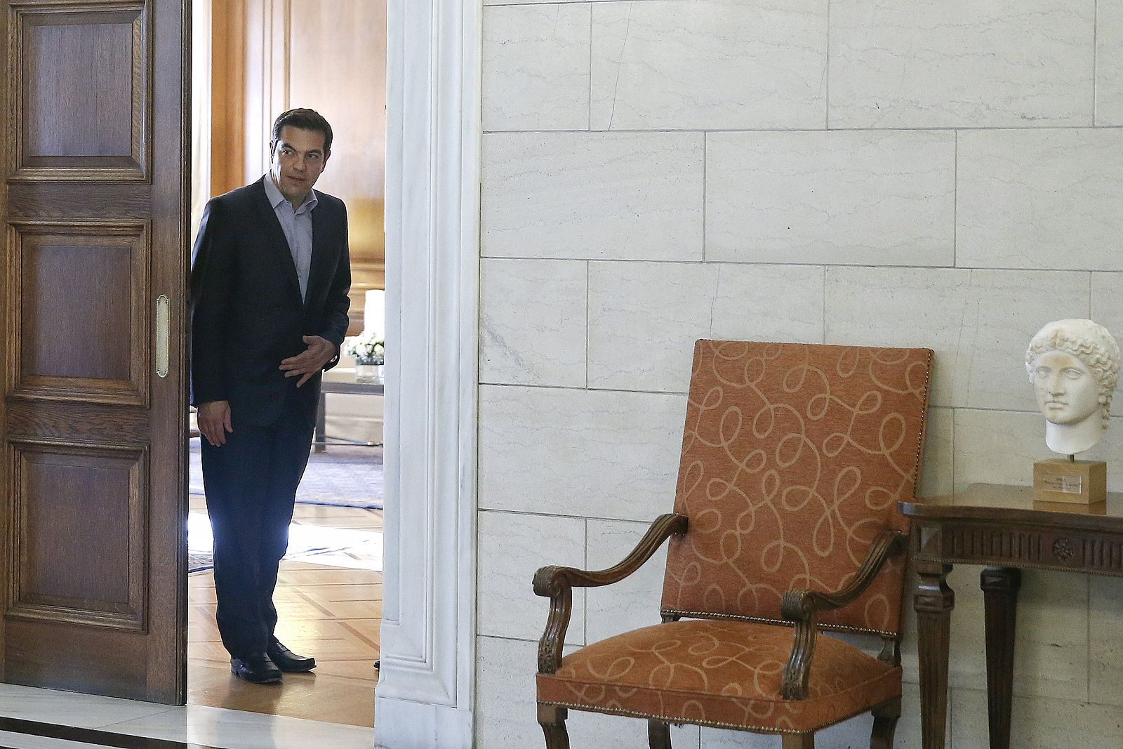 El primer ministro griego, Alexis Tsipras, se asoma a la puerta de su oficina en Atenas