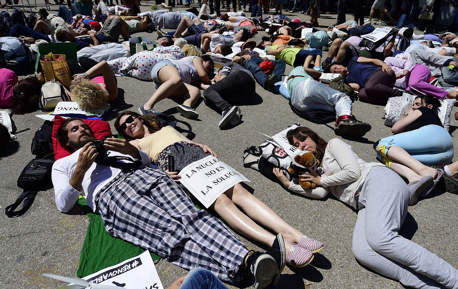 Varias personas con pijamas y almohadas parodian a una ciudadanía dormida contra el cambio climático.