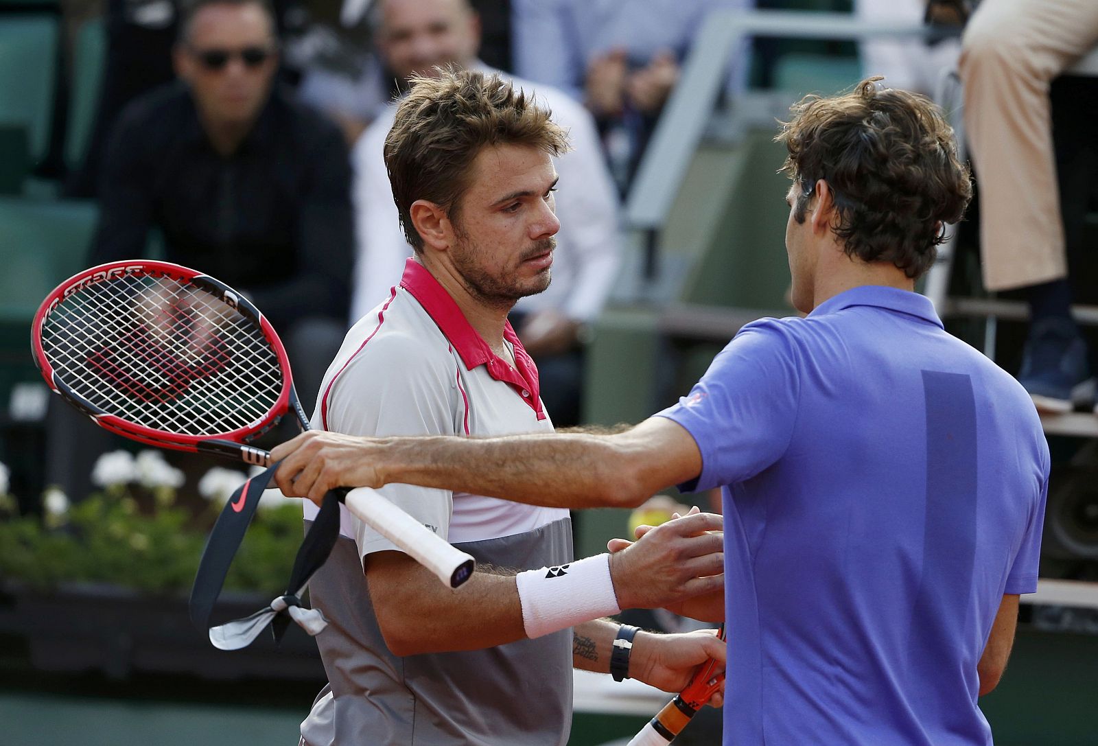 Wawrinka da la mano a su compatriota Federer después de batirle en Roland Garros.