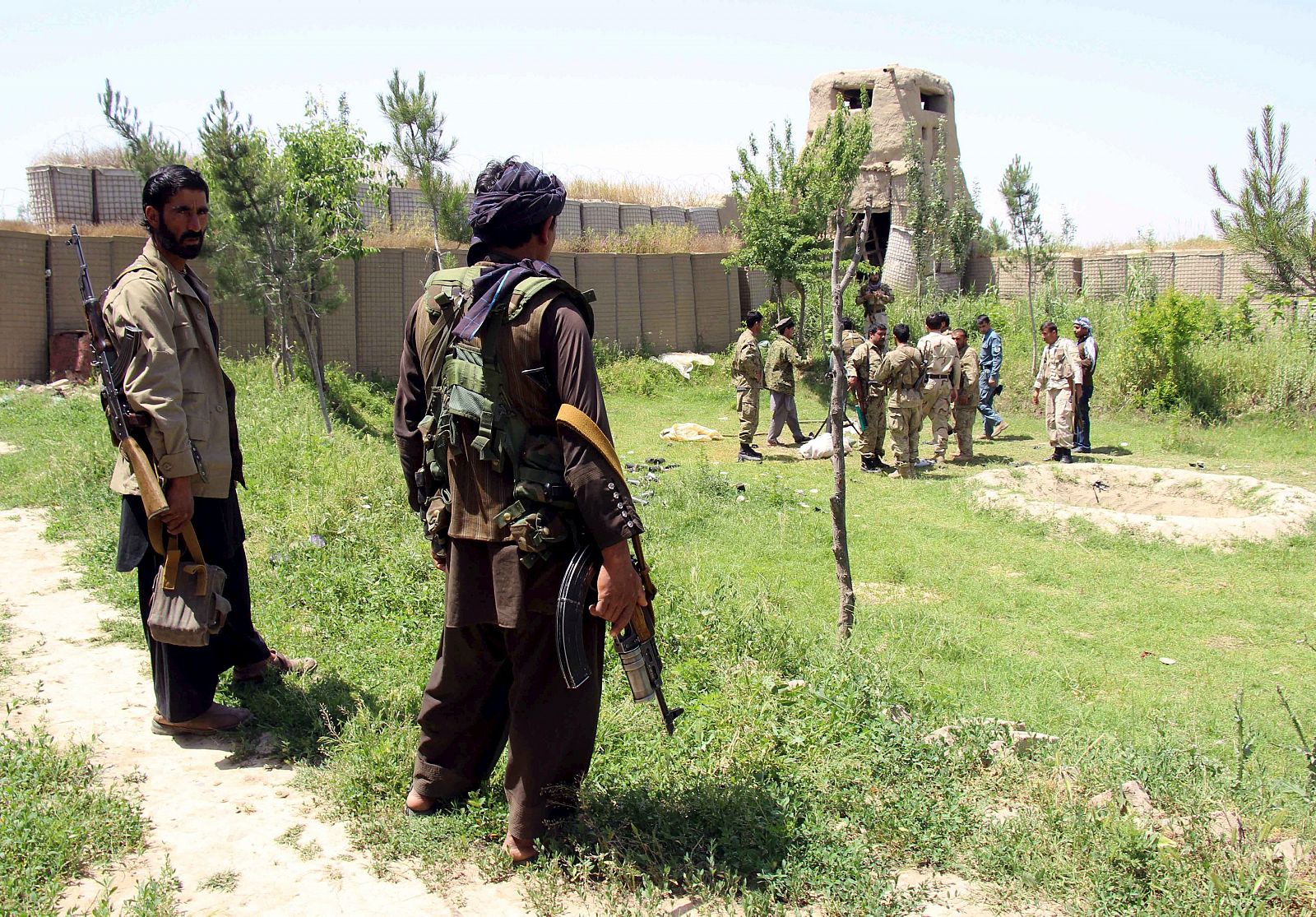 Afghan militias and policemen gather as they discuss during a battle at the Chardara district of Kunduz