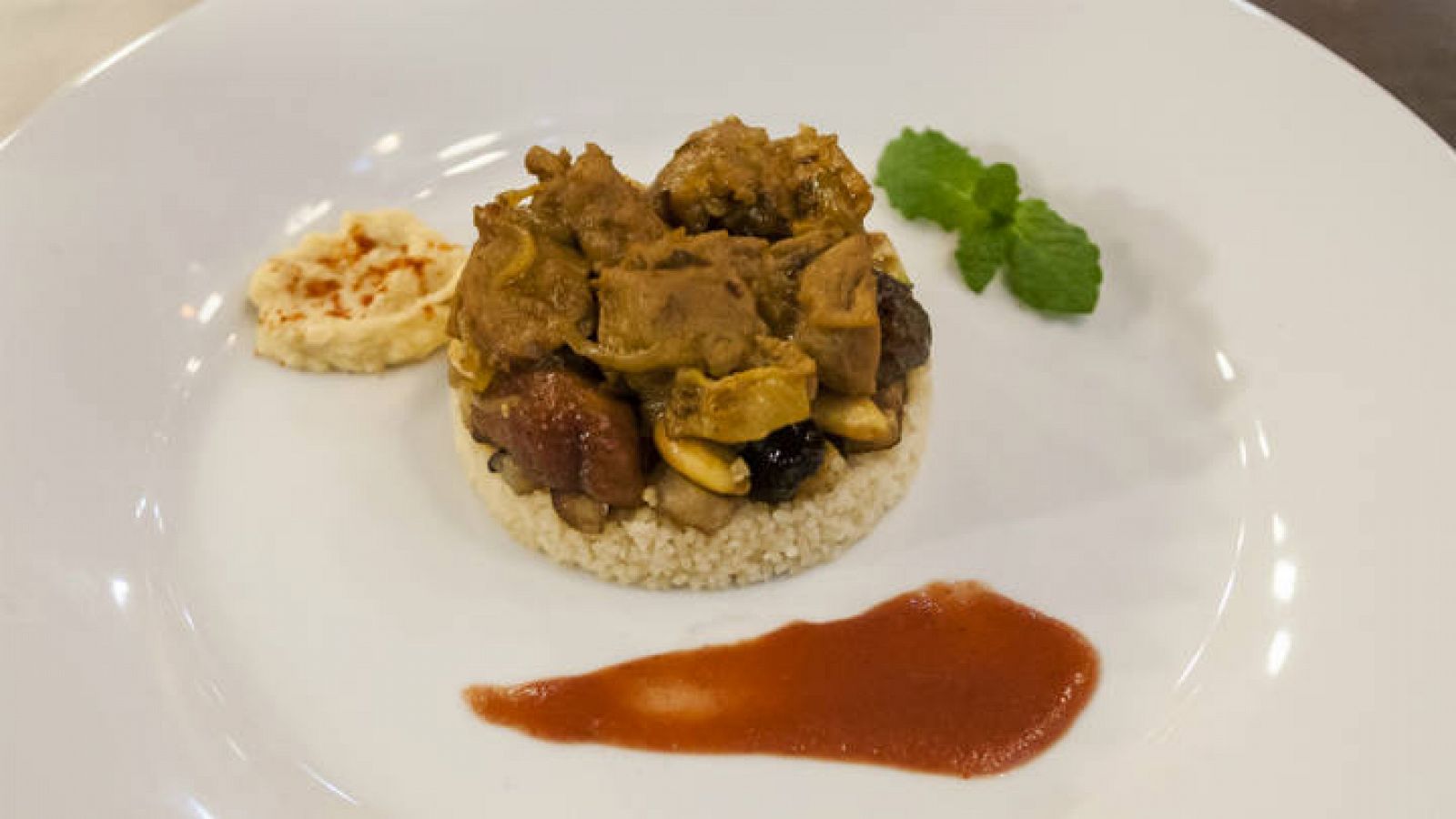 Tajine de cordero con cuscus, hummus y salsa de tomate y olivas negras