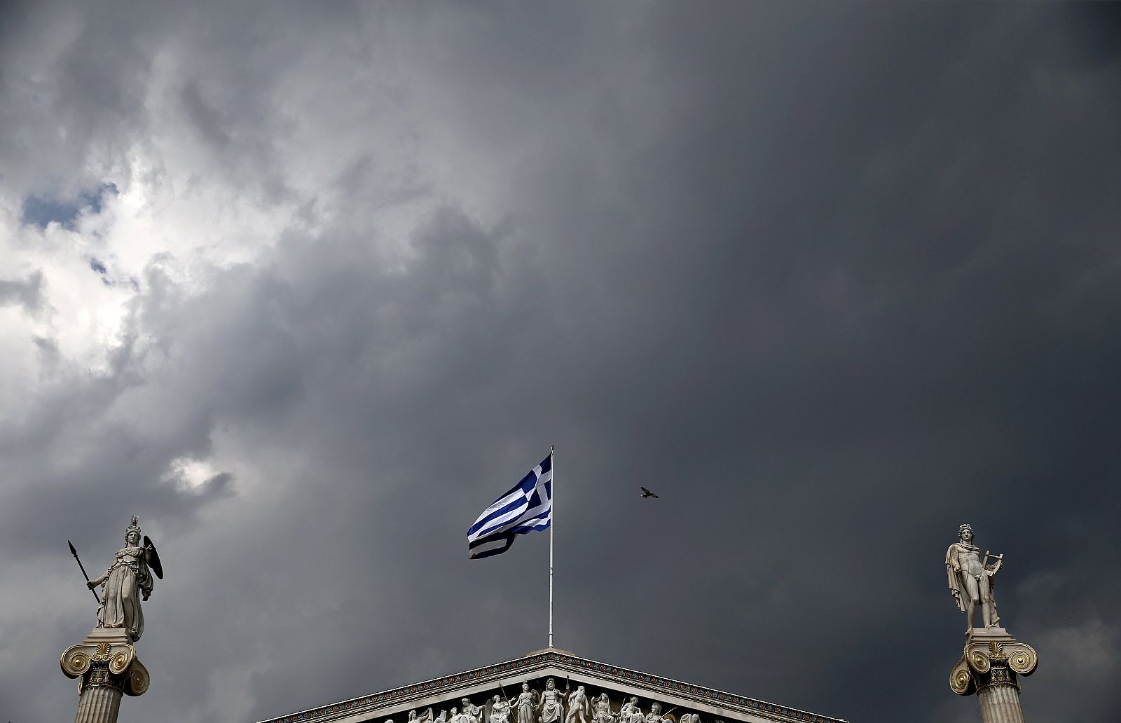 La bandera de Grecia ondea en la fachada de la Academia de Atenas