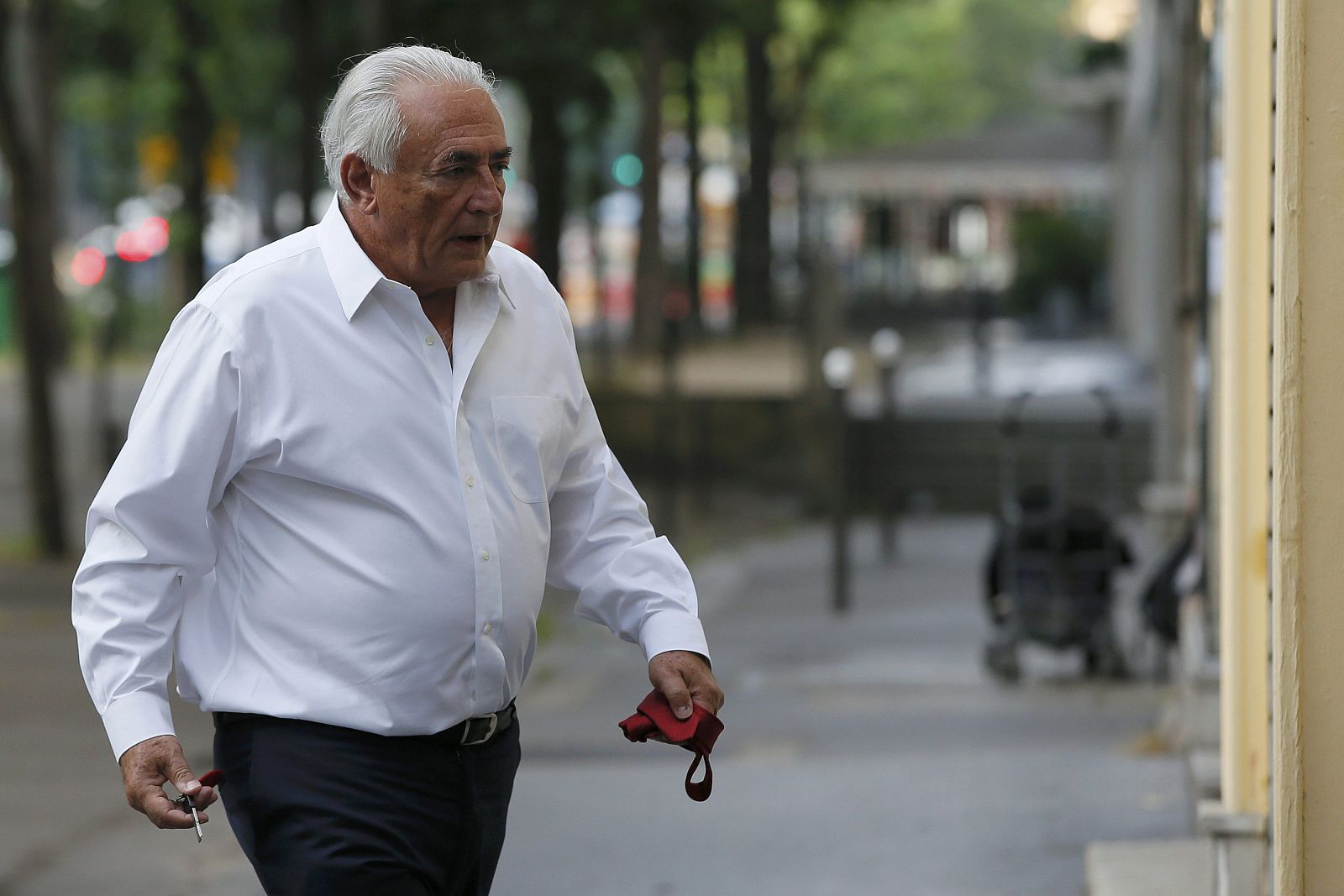Former FMI head Dominique Strauss-Kahn holds keys and a tie as he walks towards his apartment in Paris