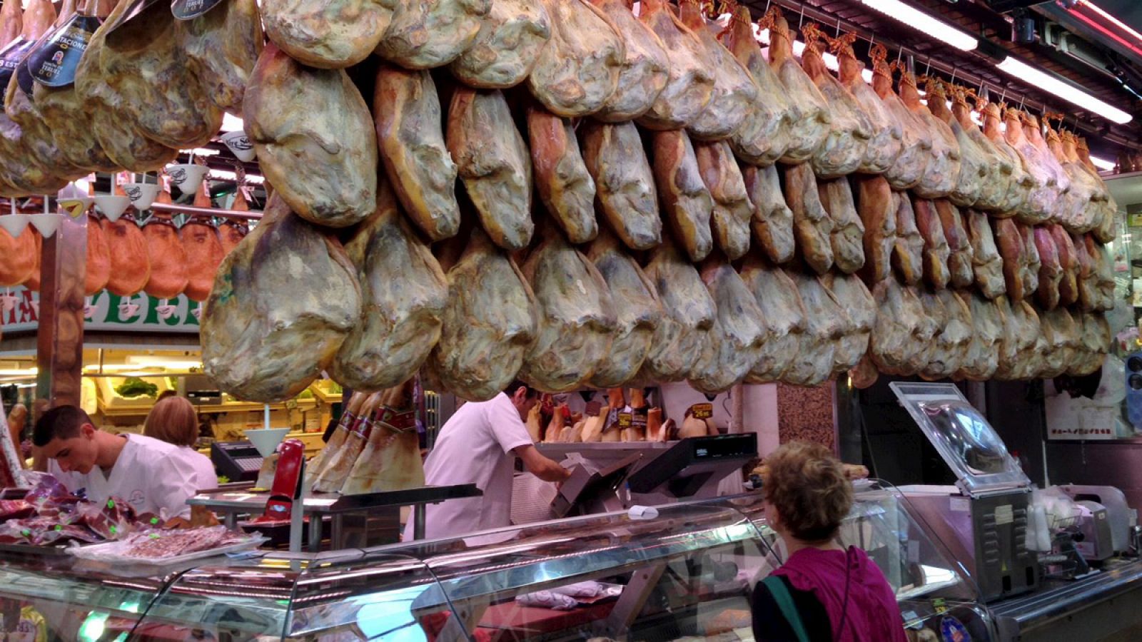 Una mujer compra jamón en el mercado central de Valencia