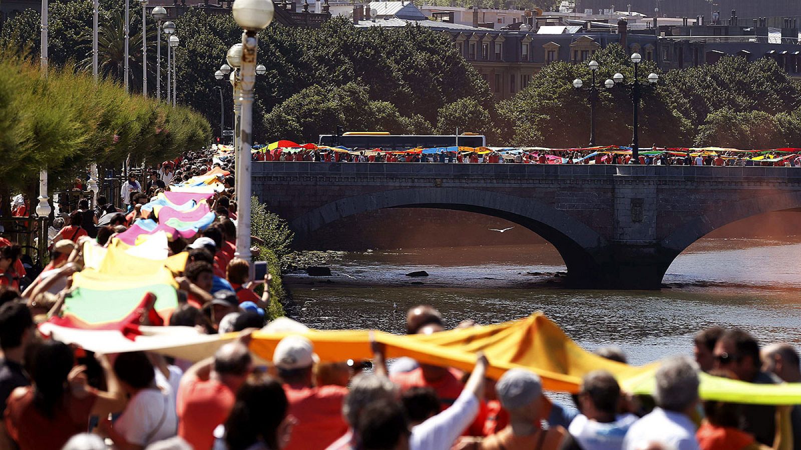 Una cadena humana de telas une los seis puentes sobre el río Urumea en San Sebastián