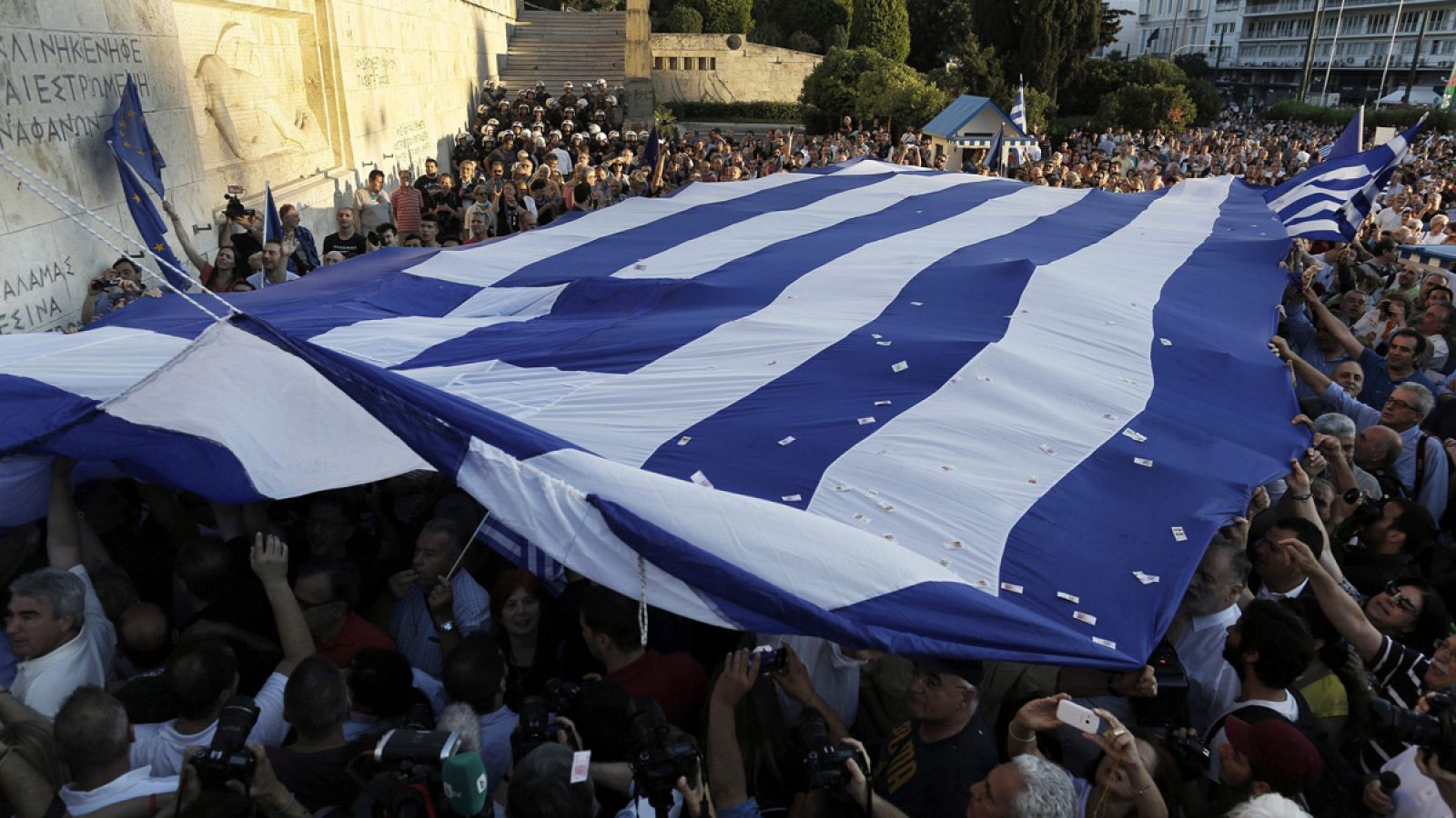 Varias personas despliegan una gran bandera griega ante Parlamento en Atenas