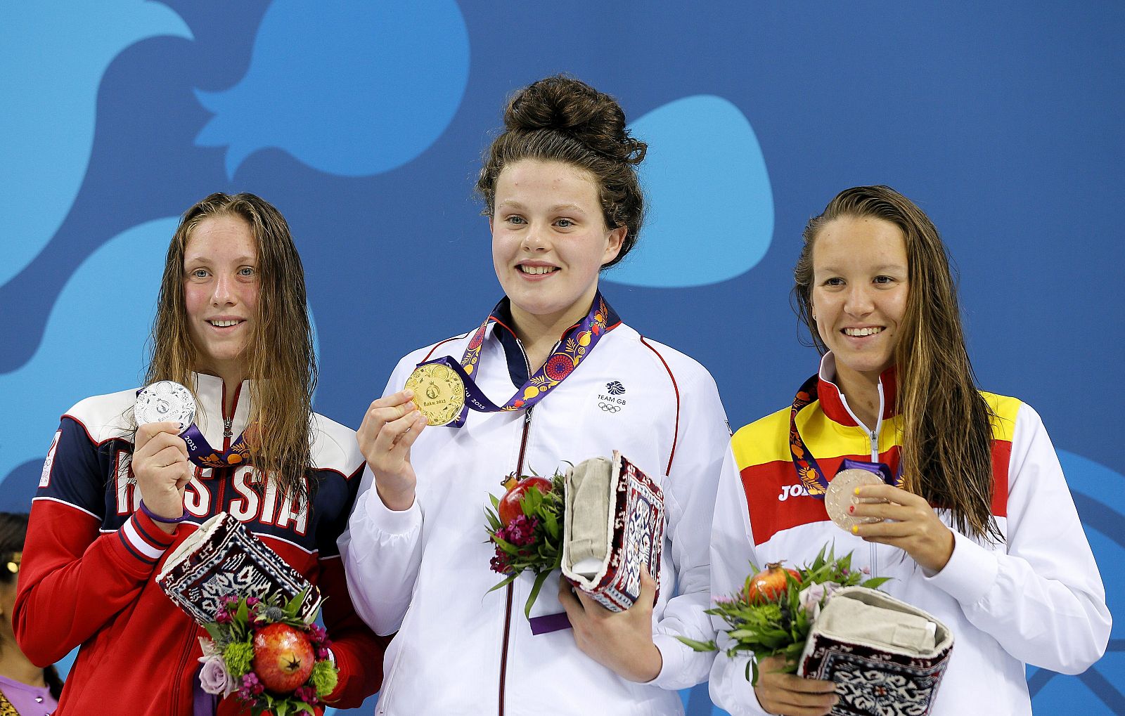La británica Holly Hibbott (c, oro) posa en el podio junto a la rusa Anastasiia Kirpichnikova (i, plata), y la española Marina Castro Atalaya (d, bronce), tras competir en la prueba de 800 metros.