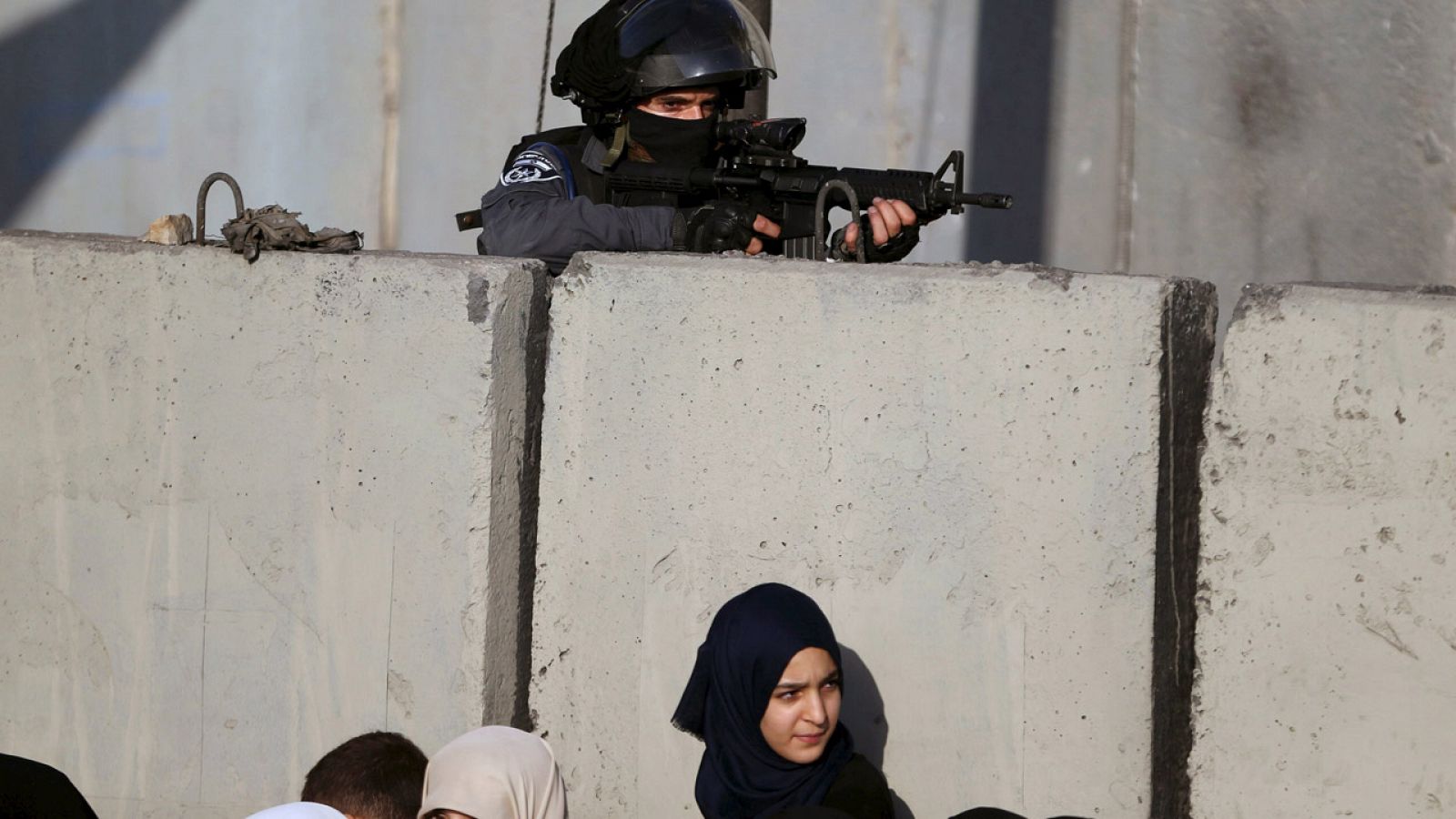 Un policía israelí y una palestina en el paso de Qalandia