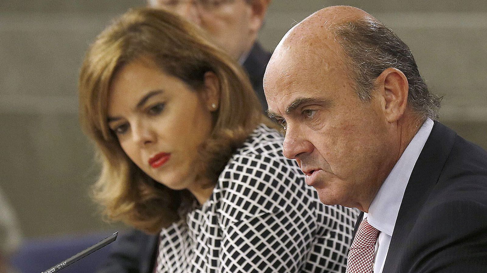 Soraya Sáenz de Santamaría junto a los ministros Rafael Catalá, (iz),y Economía, Luis de Guindos, durante la rueda de prensa posterior a la reunión del Consejo de Ministros