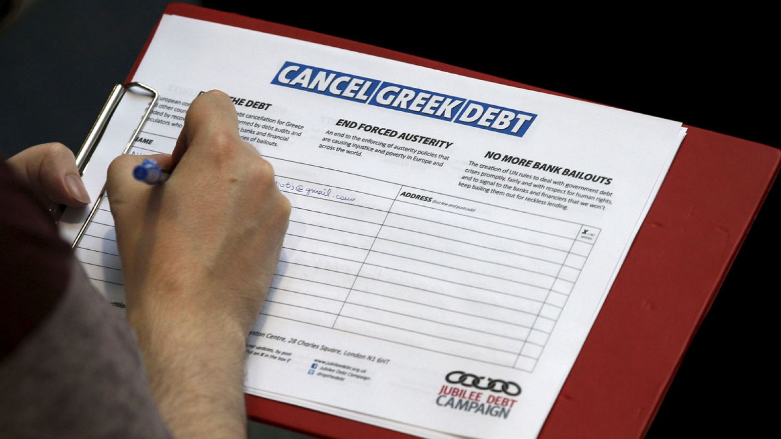 Un hombre firma la petición para cancelar la deuda de Grecia en una manifestación de apoyo a Grecia en Londres