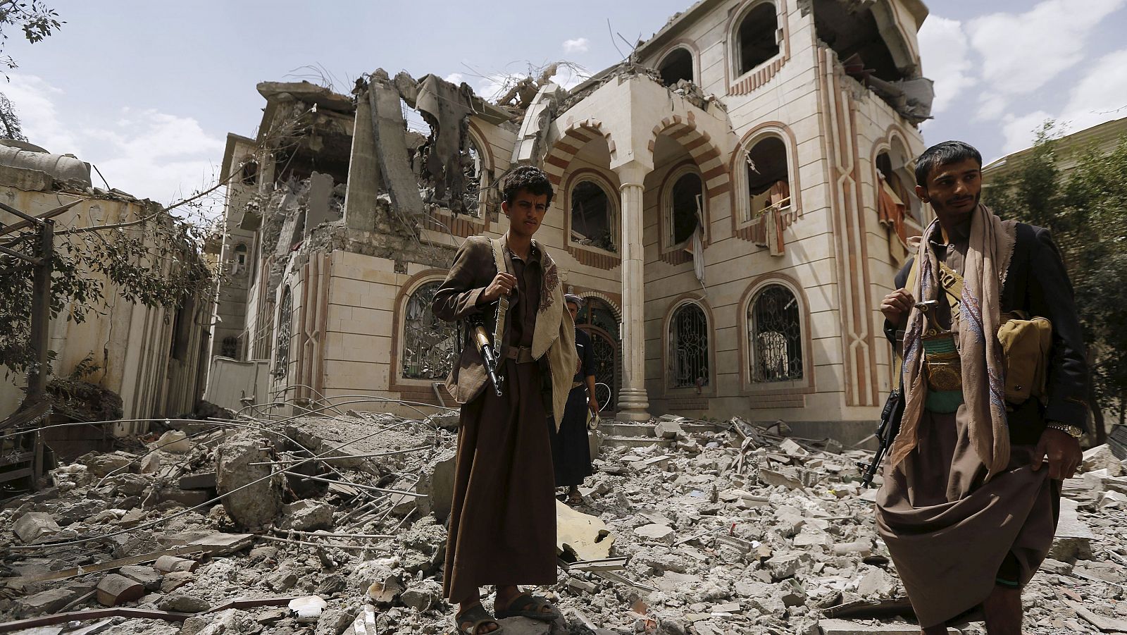 Guards stand on the rubble of the house of Brigadier Khaled al-Anduli, an army commander loyal to the Houthi movement, after it was hit by Saudi-led air strikes in Yemen's capital Sanaa