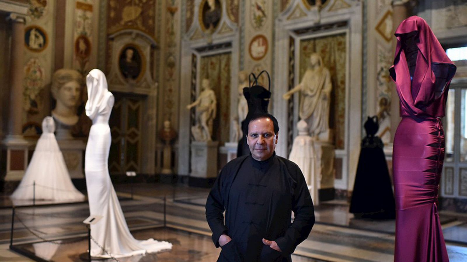 El diseñador Azzedine Alaïa posa junto a sus vestidos en la galería Borghese.