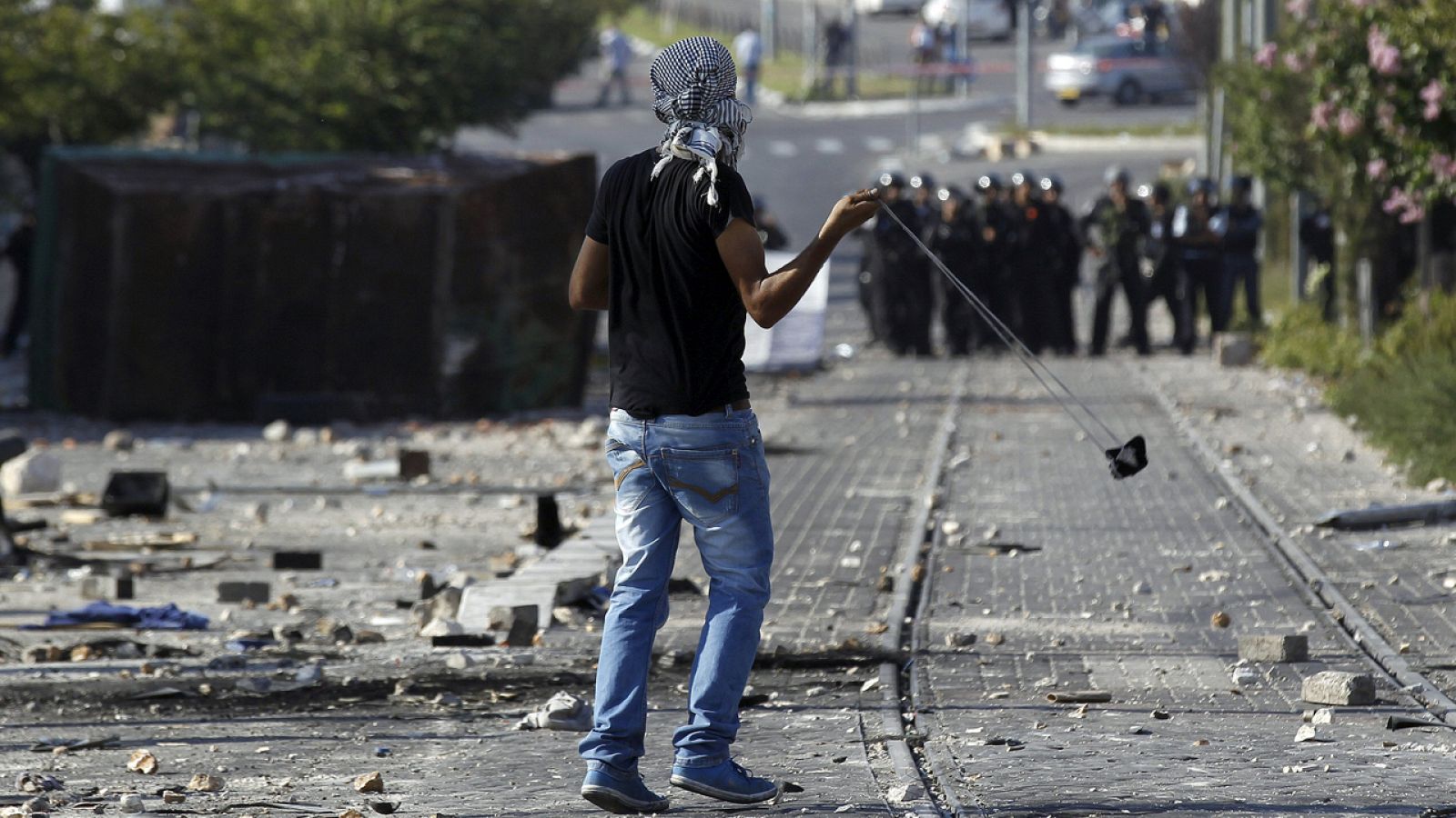 Un palestino tira piedras a agentes israelíes