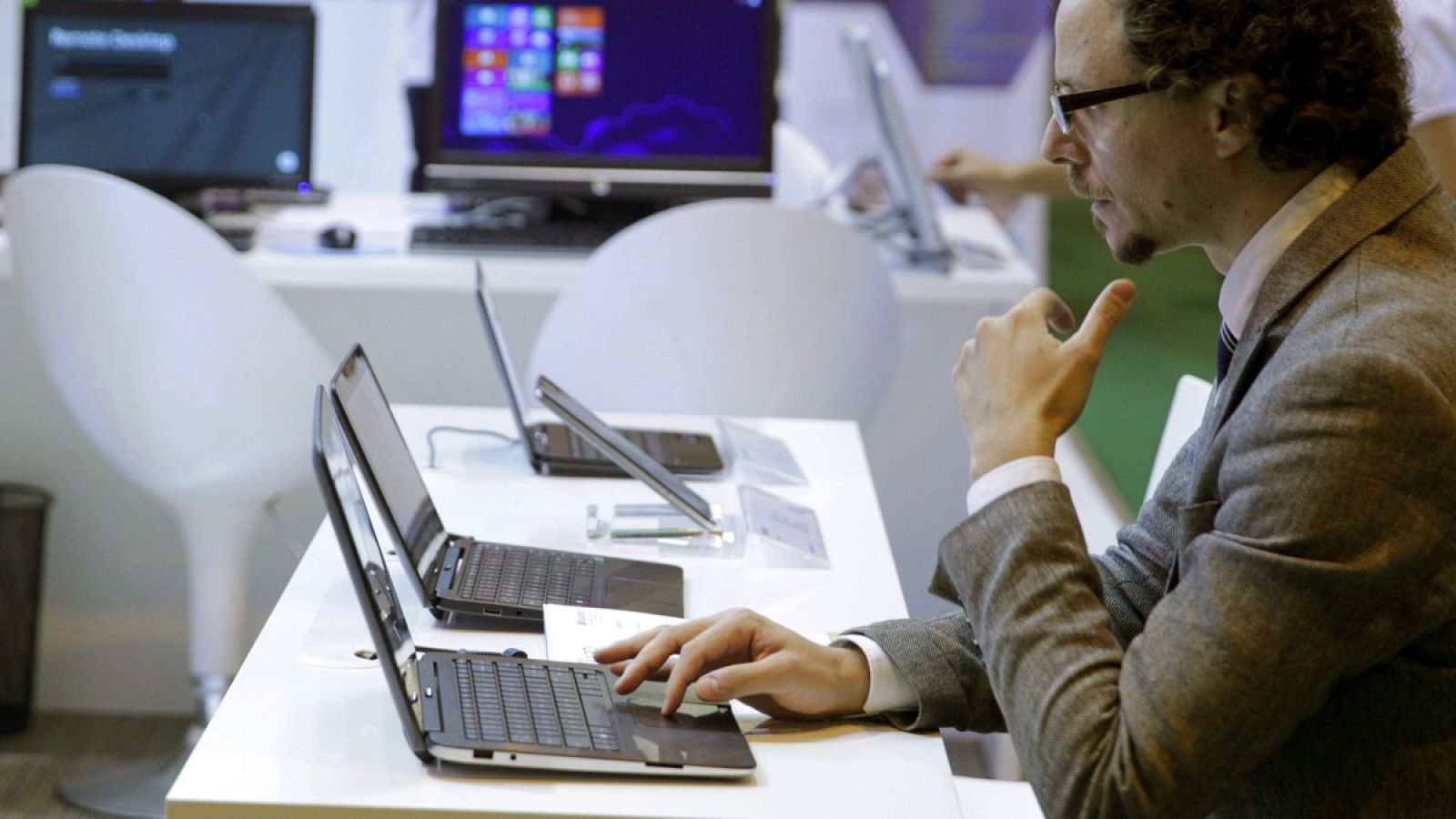 Un hombre observa las aplicaciones de uno de los ordenadores que se muestran en la feria tecnológica SIMO Network 2013