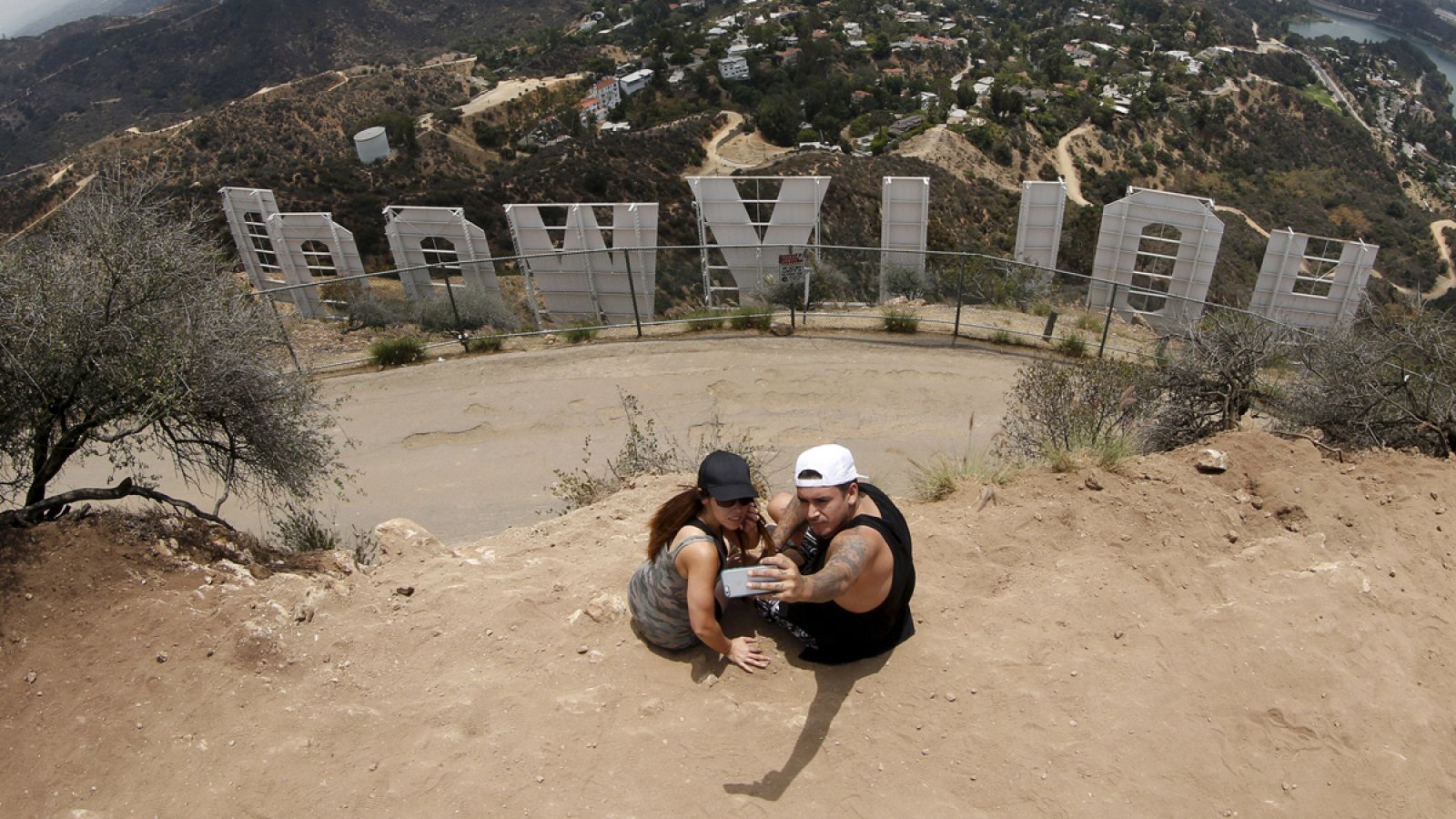 Una pareja se fotografía con el letrero de Hollywood en Los Ángeles