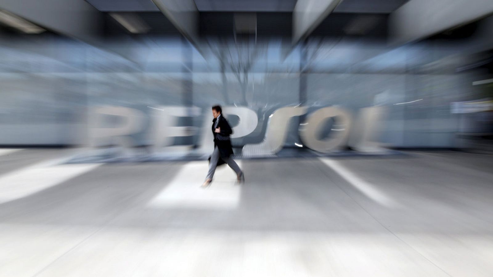 Una mujer sale de la sede de Repsol en Madrid