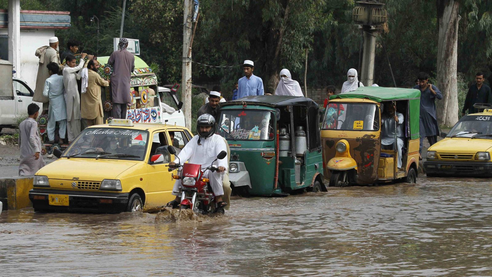 Vehículos circulan por una calle inundada en Peshawar, Pakistán