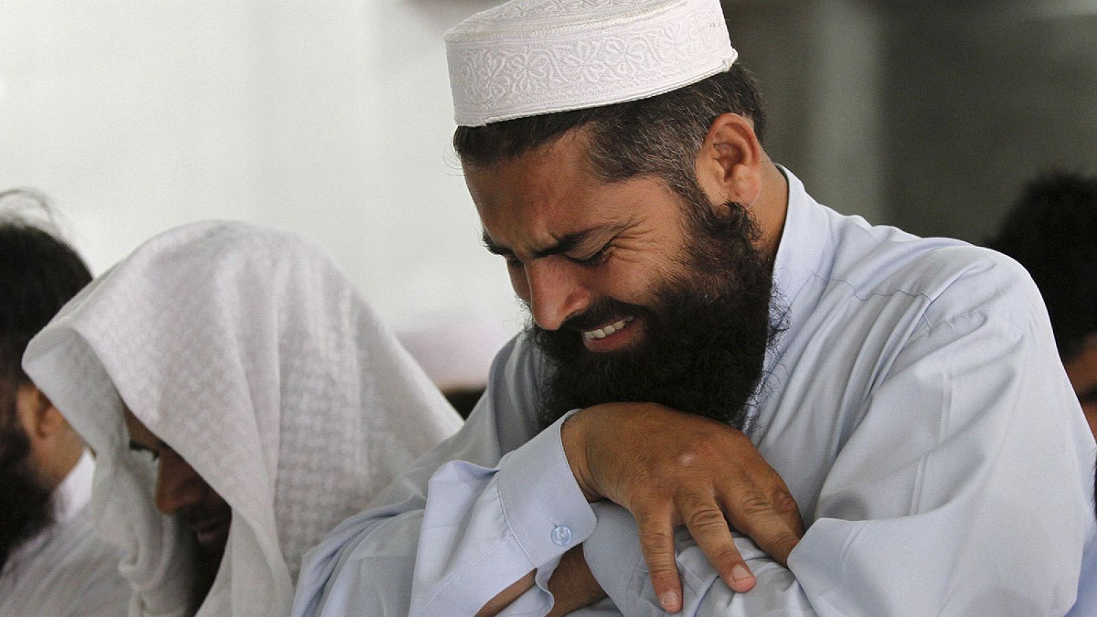 Un hombre llora en un funeral por el mulá Omar en Peshawar