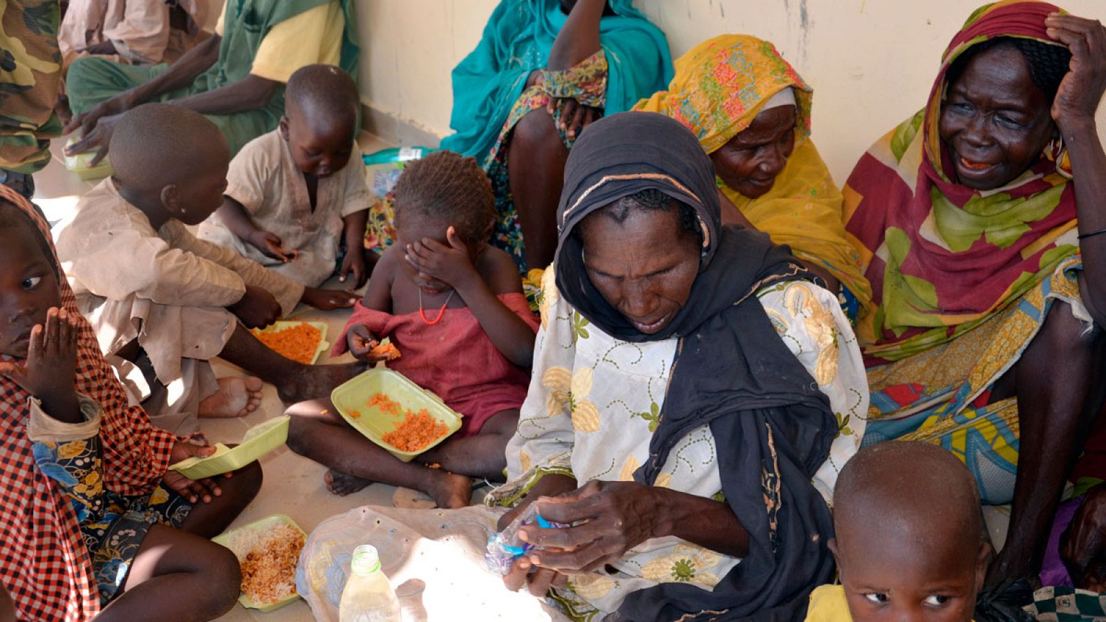 Un grupo de mujeres y niños rescatados el pasado jueves de las manos de Boko Haram come en un cuartel del ejército nigeriano en la región de Bono.