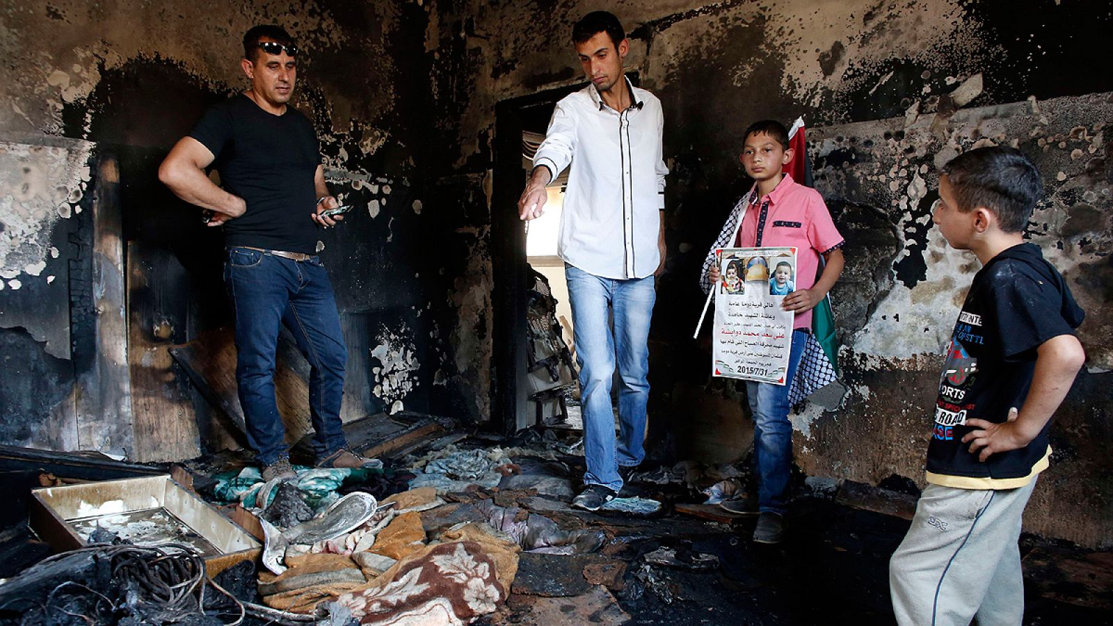 Un grupo de palestinos examina los daños en el interior de la vivienda en la que murió el bebé