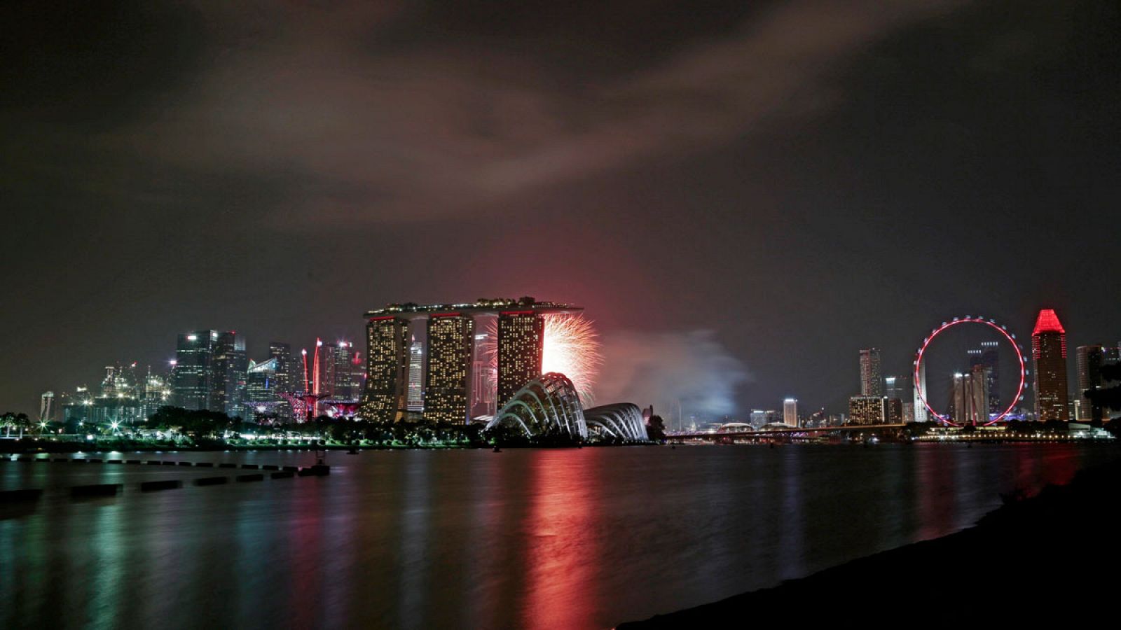 Vista de la ciudad-estado de Singapur desde la bahía durante uno de los espectáculos pirotécnicos por el 50 aniversario de su independencia.