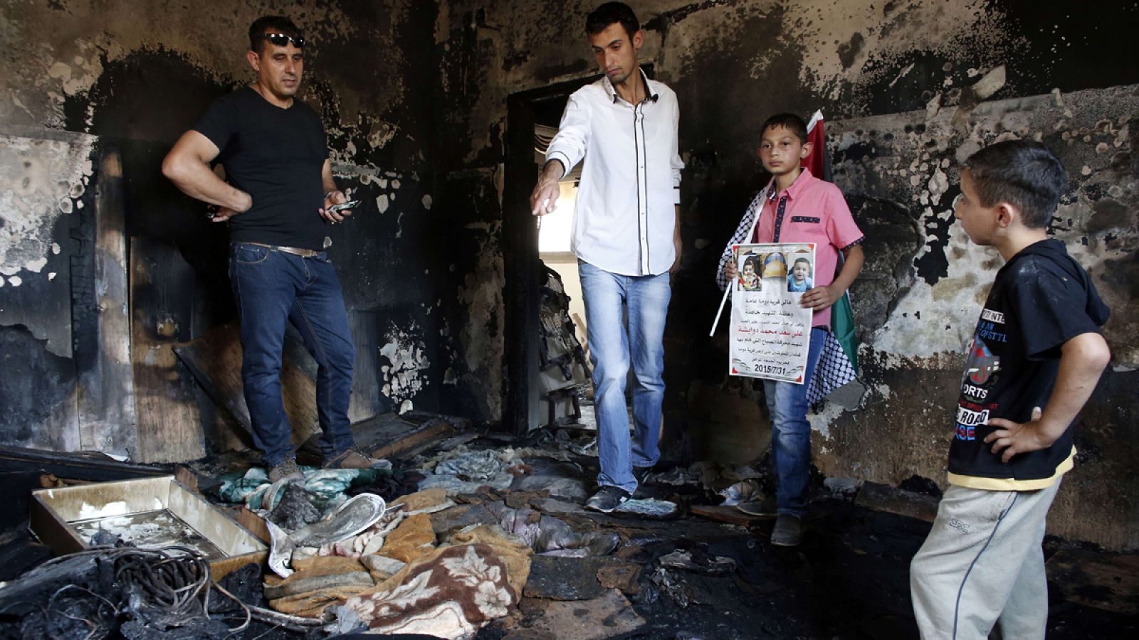 Palestinos contemplan la casa quemada en la que murió un bebé de 18 meses tras un incendio provocado por radicales israelíes