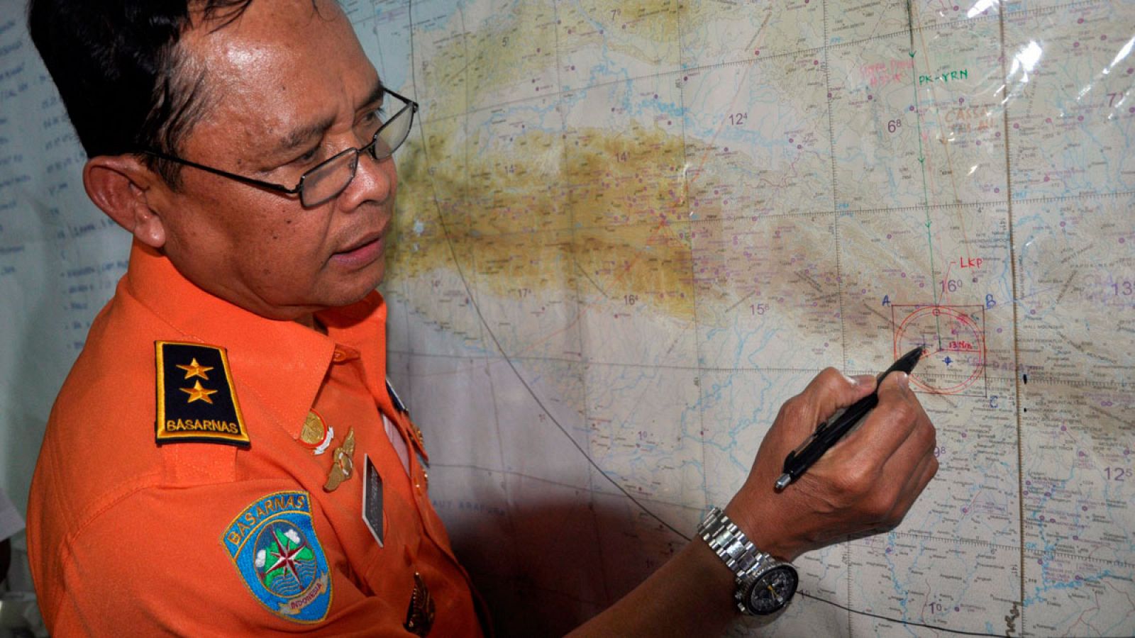 Un funcionario de los servicios indonesios de rescate señala en un mapa el punto donde se están realizando las labores de búsqieda.