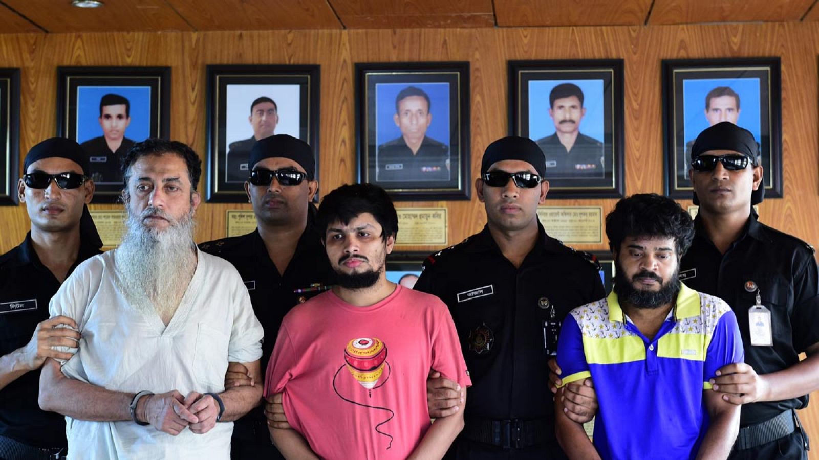 La fuerza de Acción Rápida de Bangladesh (RAB) acompaña a los sospechosos Touhidur Rahman (a la derecha), Sadek Ali (en el centro y Aminul Mallick.